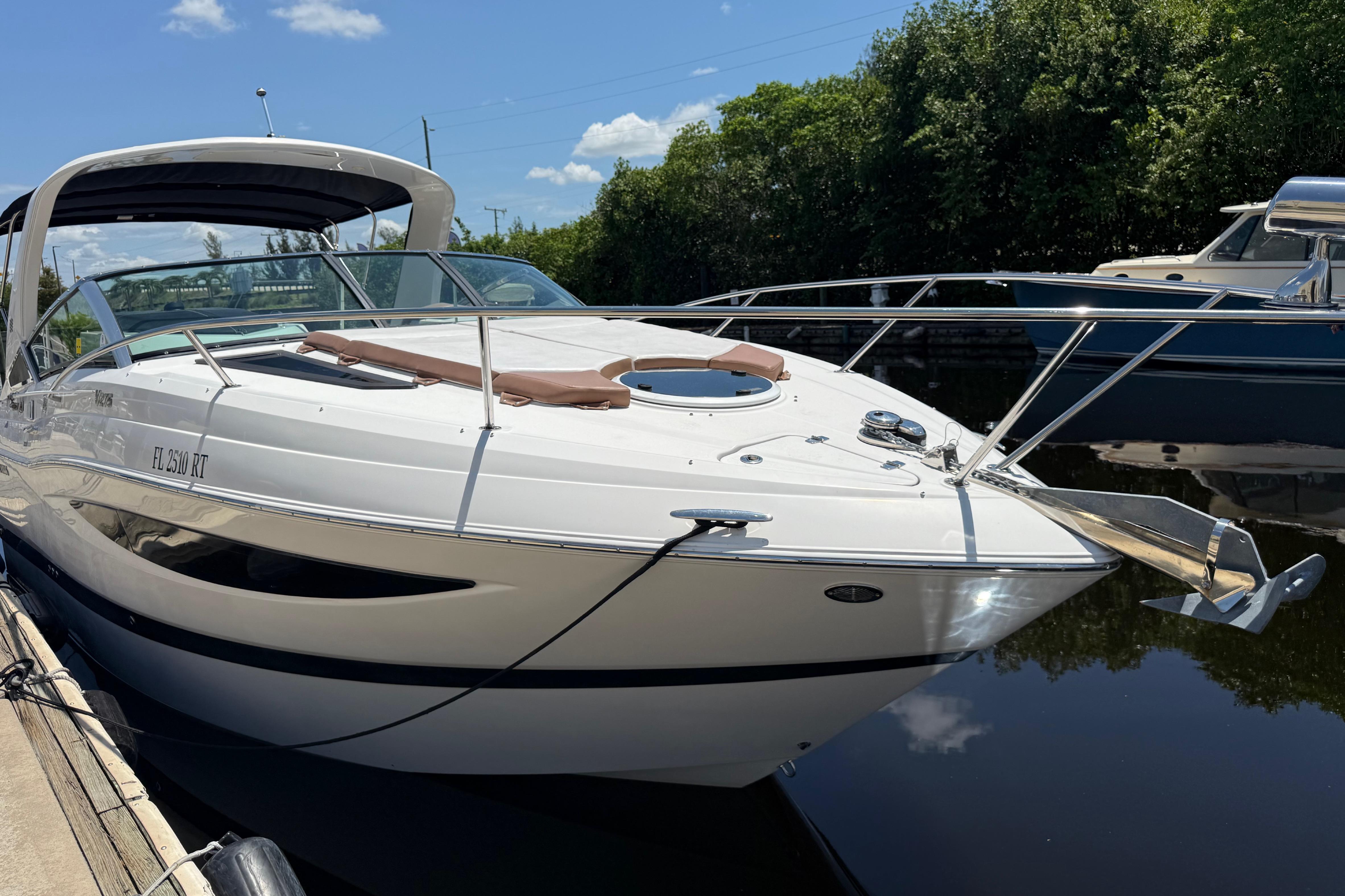 2017 Four Winns V275 boat docked on a sunny day, reflecting on calm water.
