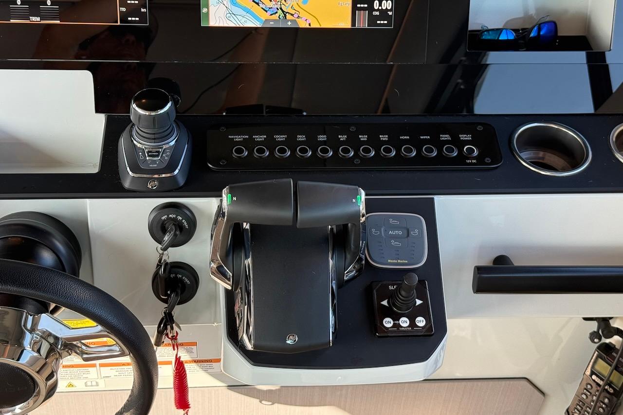 Cockpit controls of 2024 Saxdor 320 GTC boat with steering wheel and navigation system.