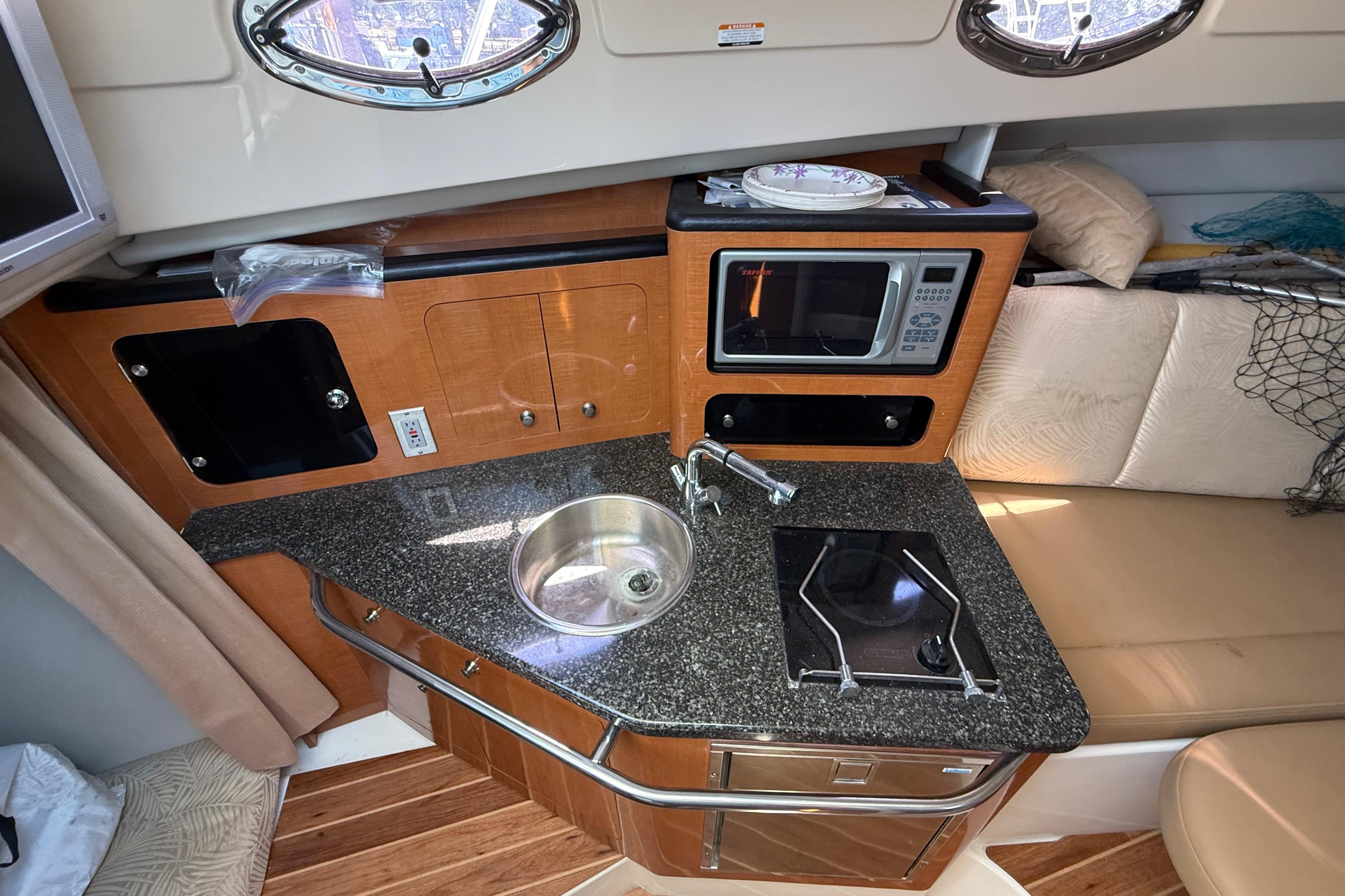 2007 Robalo R305 Walkaround boat interior with kitchenette, sink, stove, and microwave.