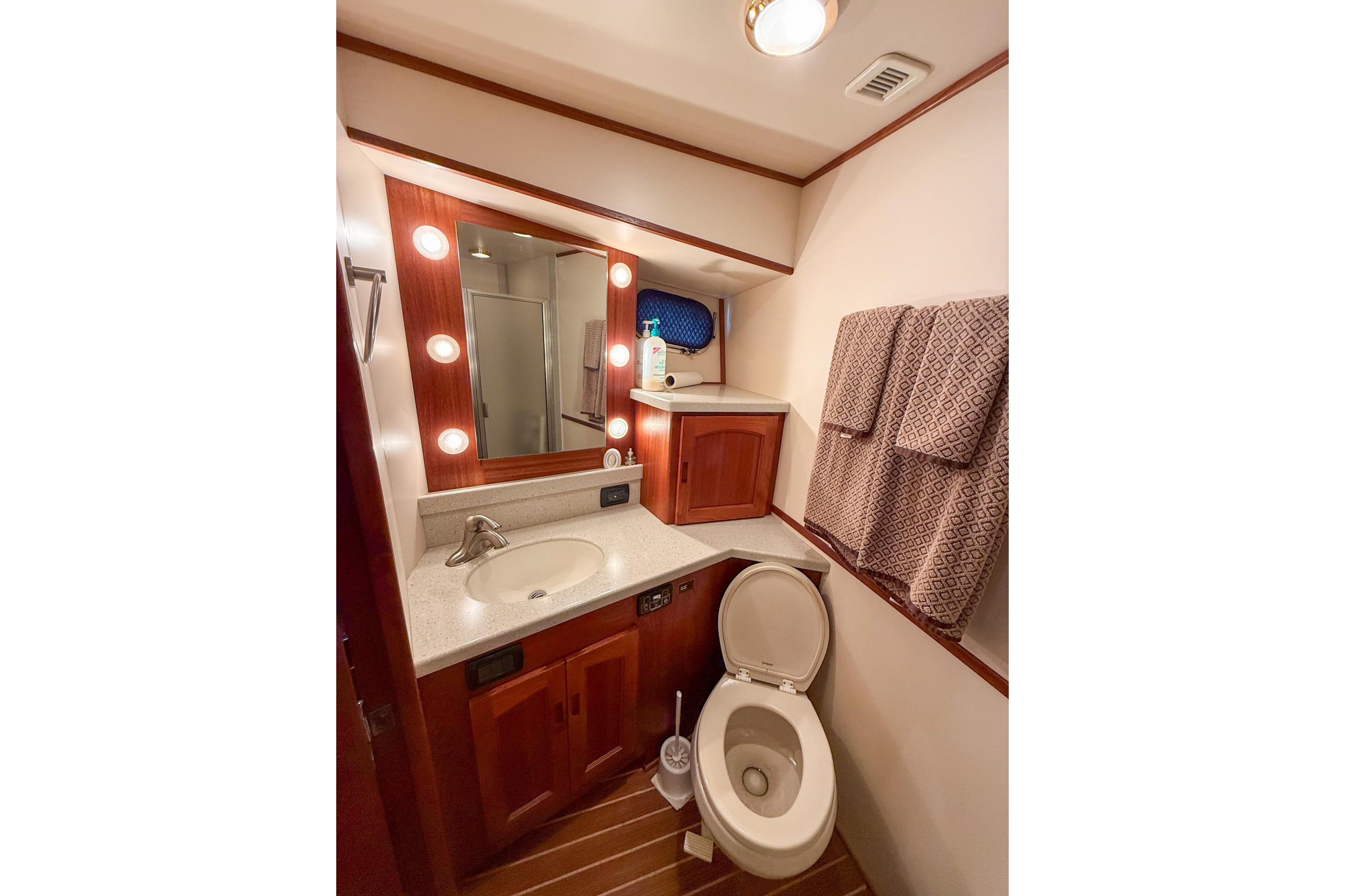 Luxurious bathroom in 2007 Nordic Tug 54 yacht with wood accents and modern fixtures.