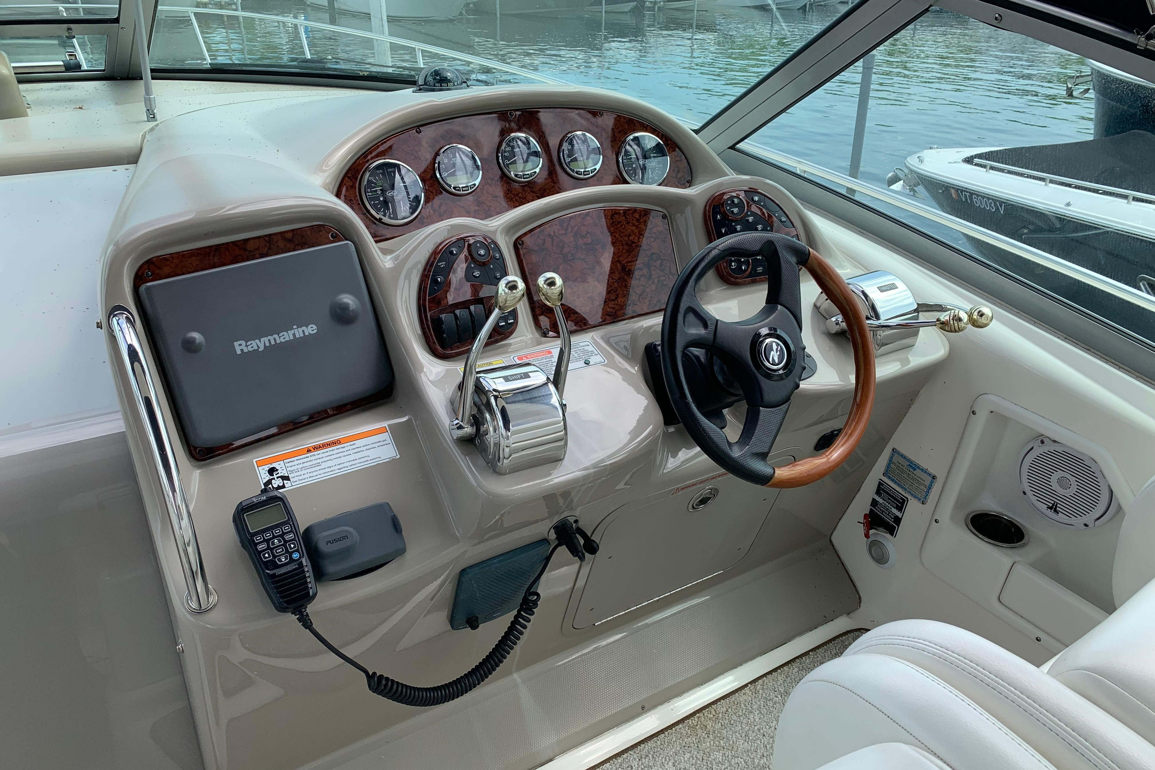 2007 Sea Ray 340 Sundancer helm with Raymarine navigation, steering wheel, and control panel.