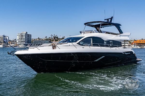 2025 Sunseeker Manhattan 68 yacht cruising in a sunny harbor.
