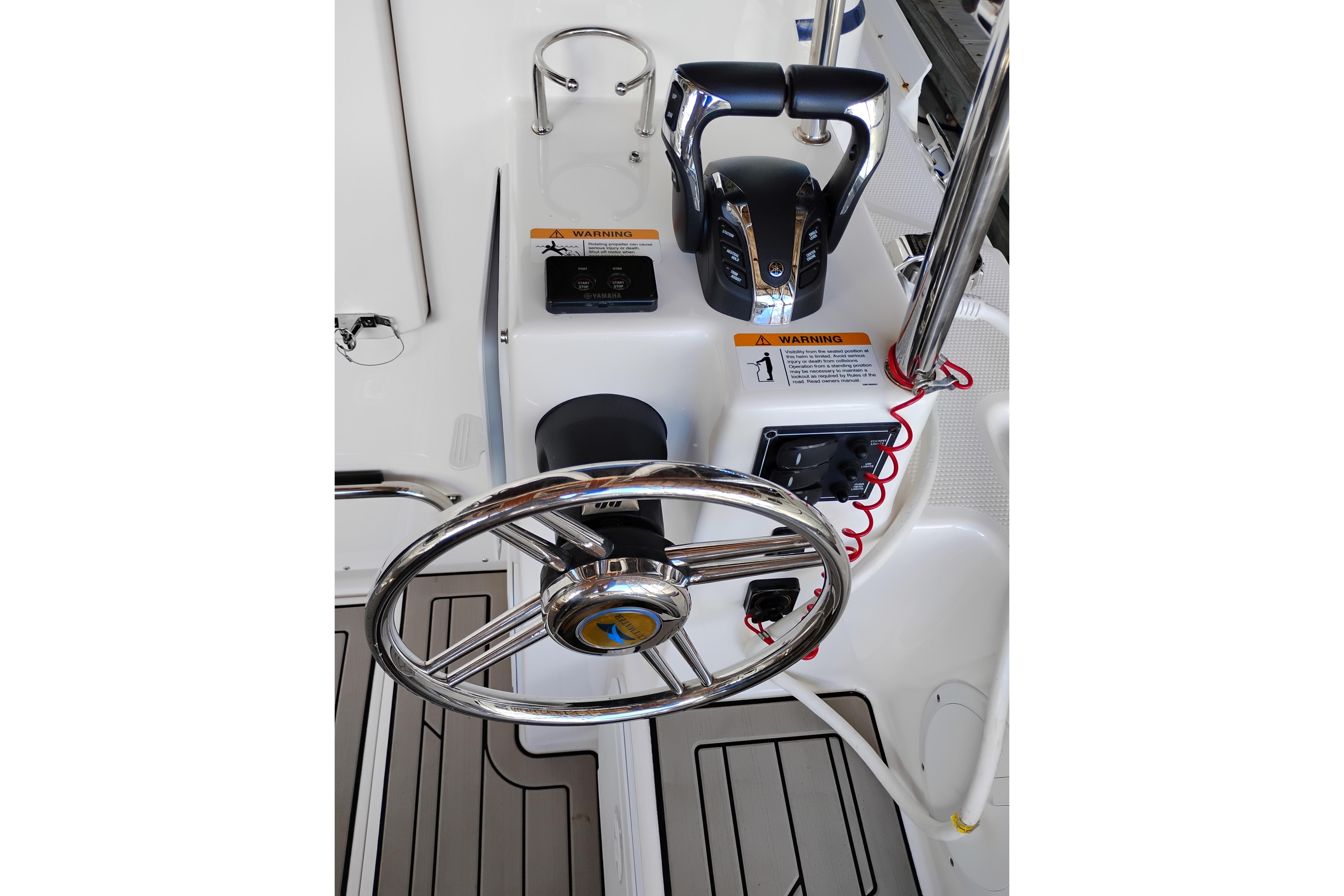 Steering wheel and controls of 2022 Cutwater C-32 Coupe boat cockpit.