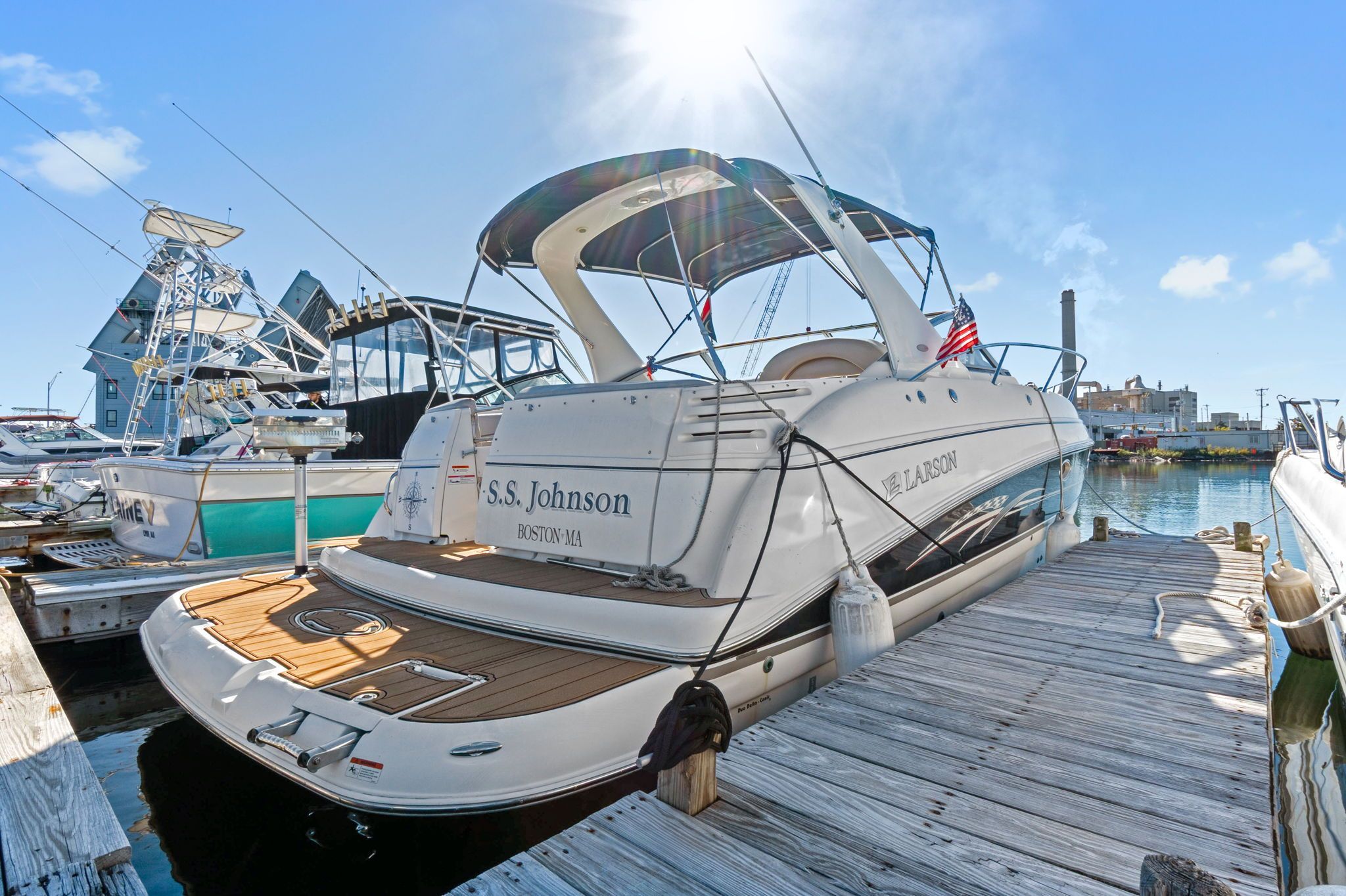 2007 Larson Cabrio 330 docked, featuring a sunshade and American flag.