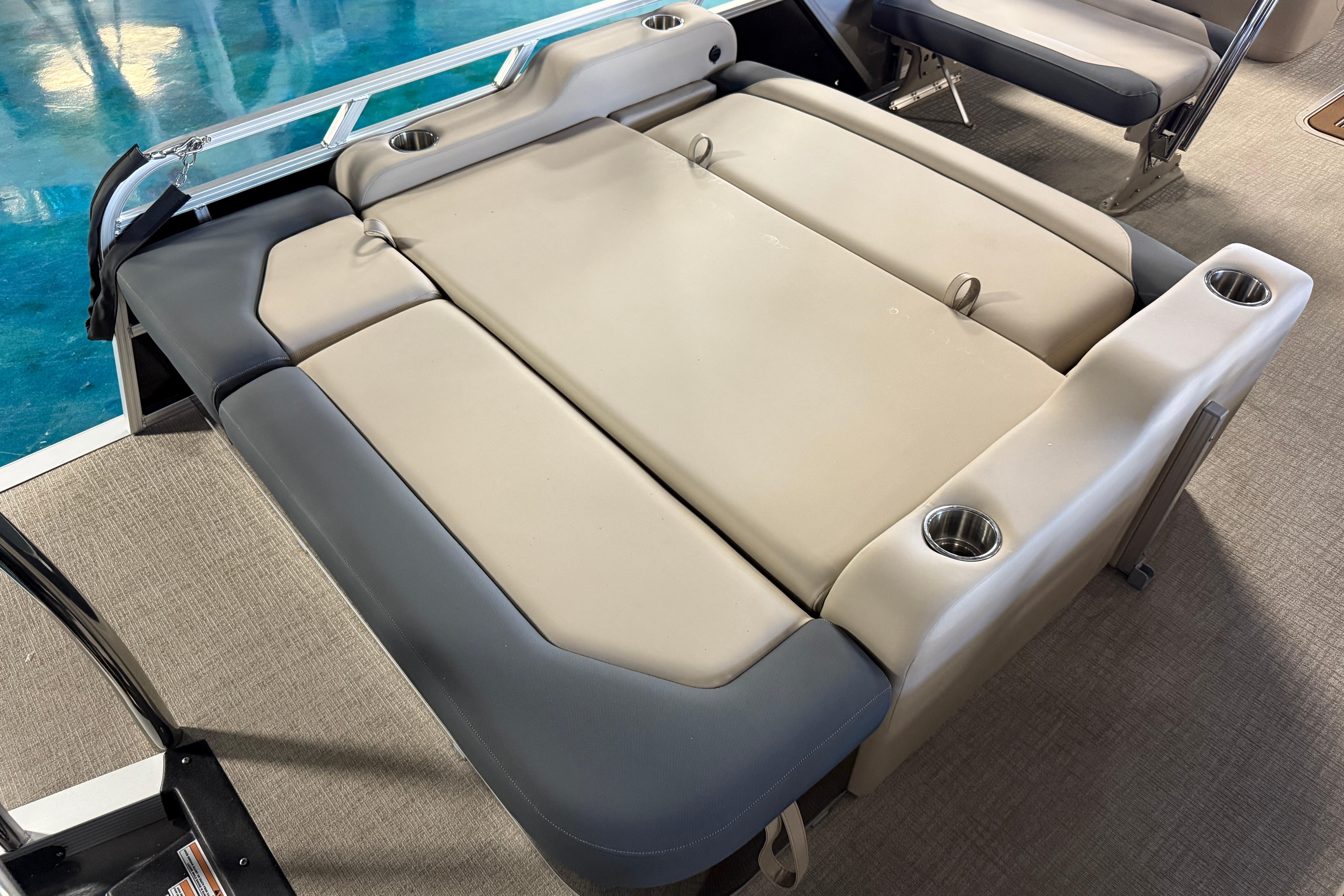 2026 Tahoe Pontoon LTZ Entertainer with beige seating and cup holders on deck.