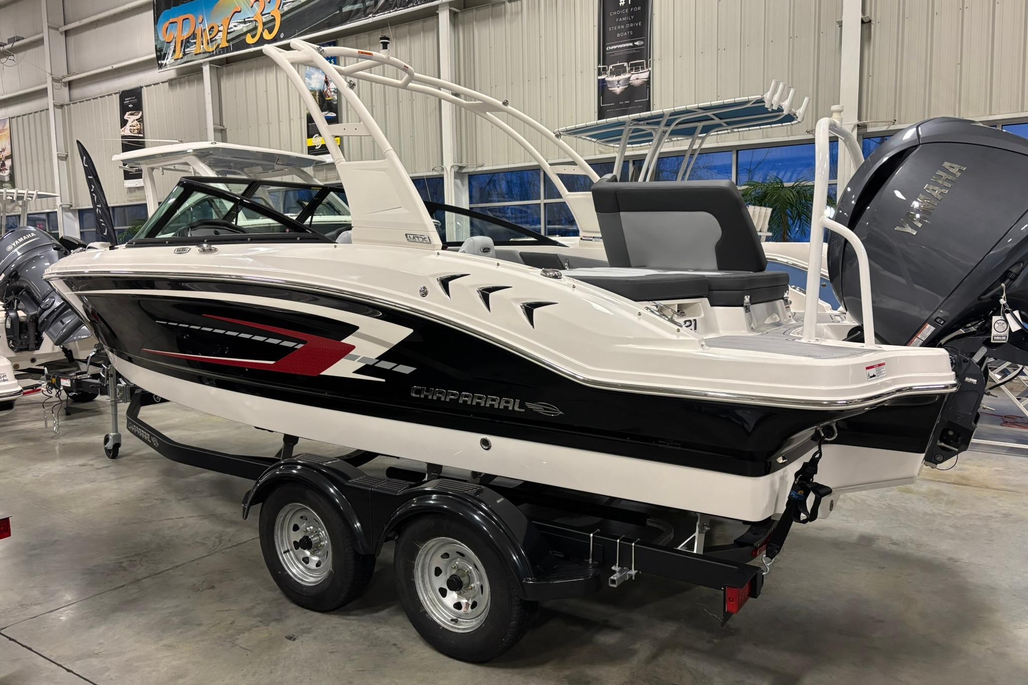 2026 Chaparral 21 SSi OB boat in showroom, sleek design, black and white color scheme.