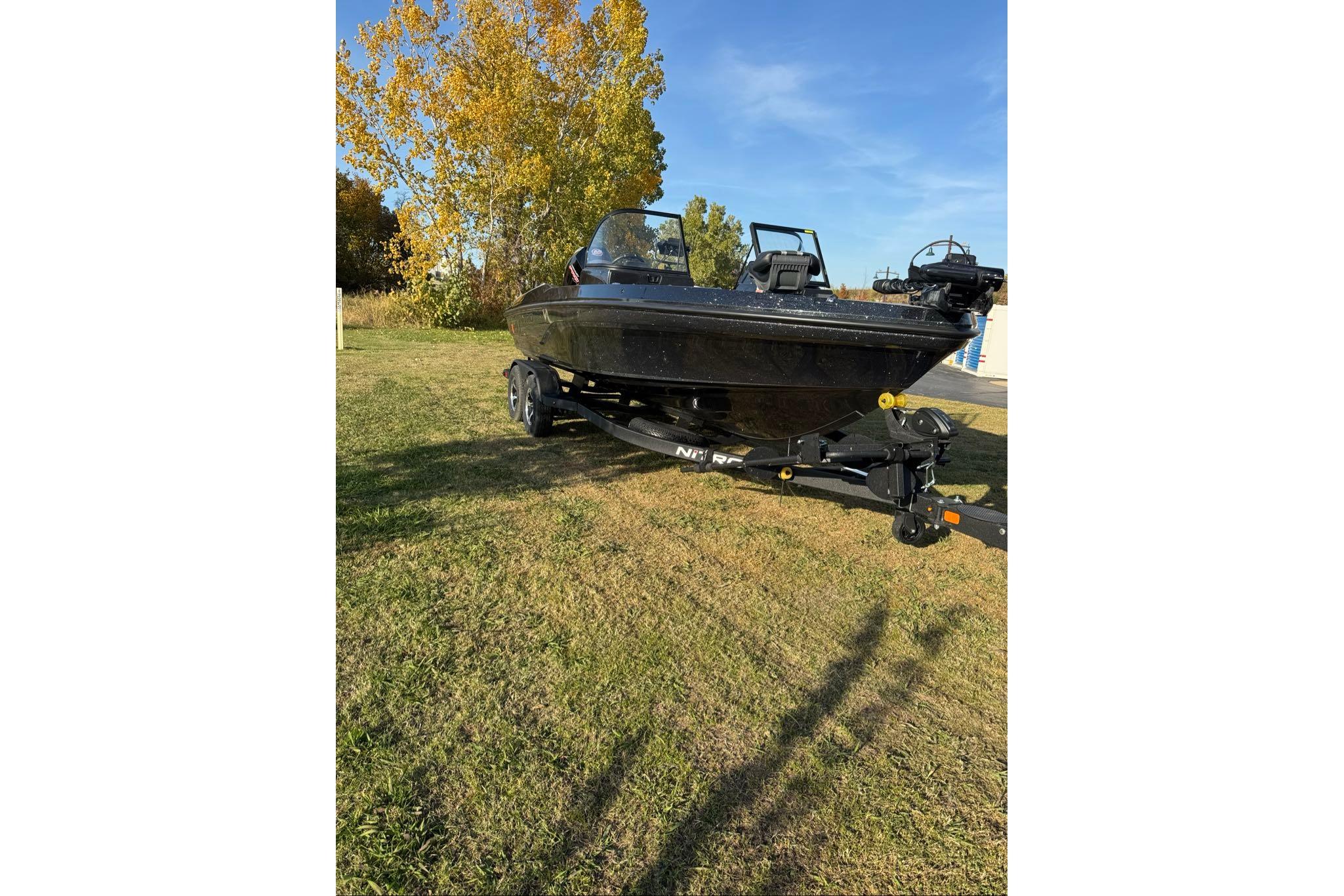 2026 Nitro ZV20 Pro boat on trailer, parked on grassy area with autumn trees.