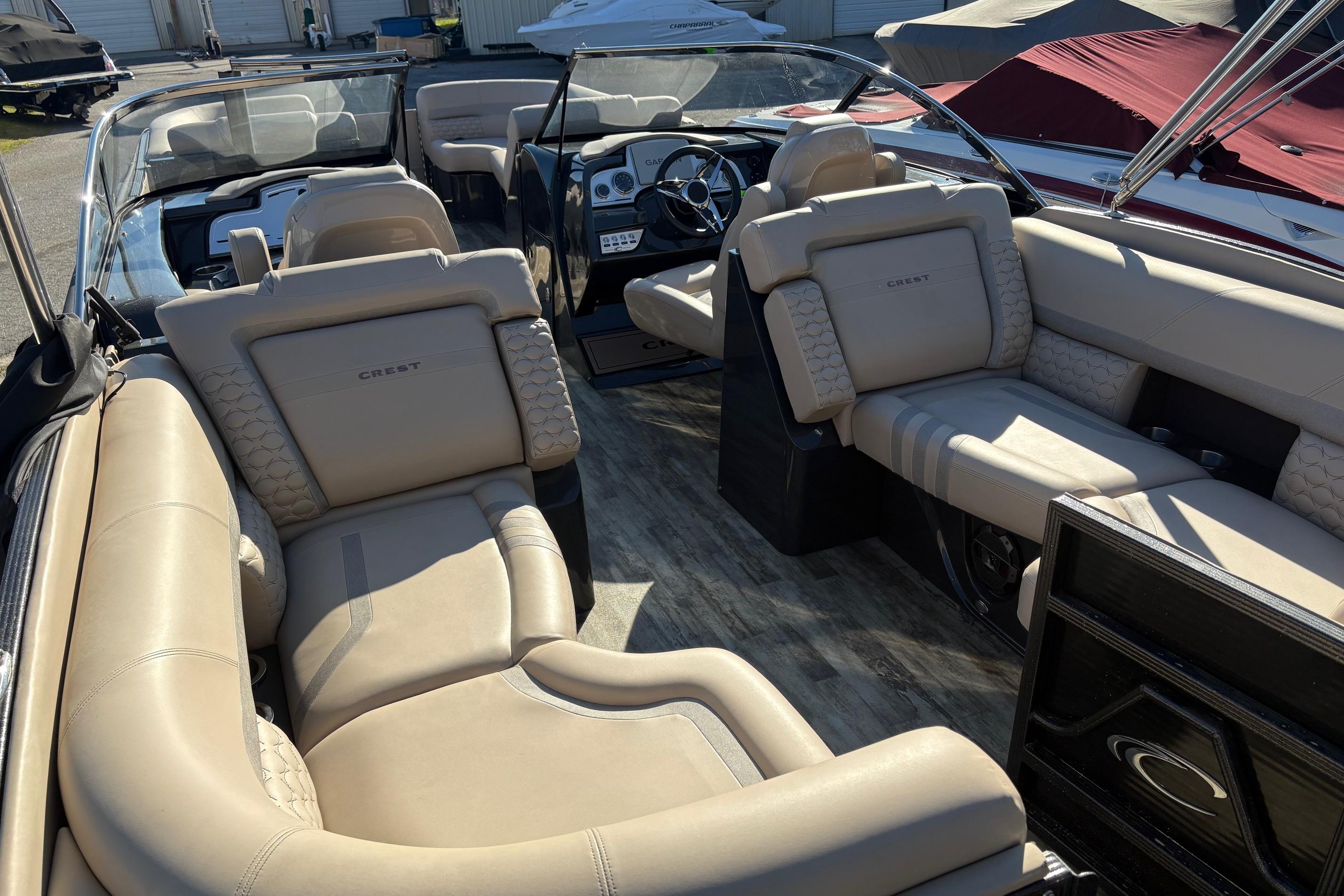 Luxurious interior of 2022 Crest Continental 250 boat with beige seating and modern dashboard.