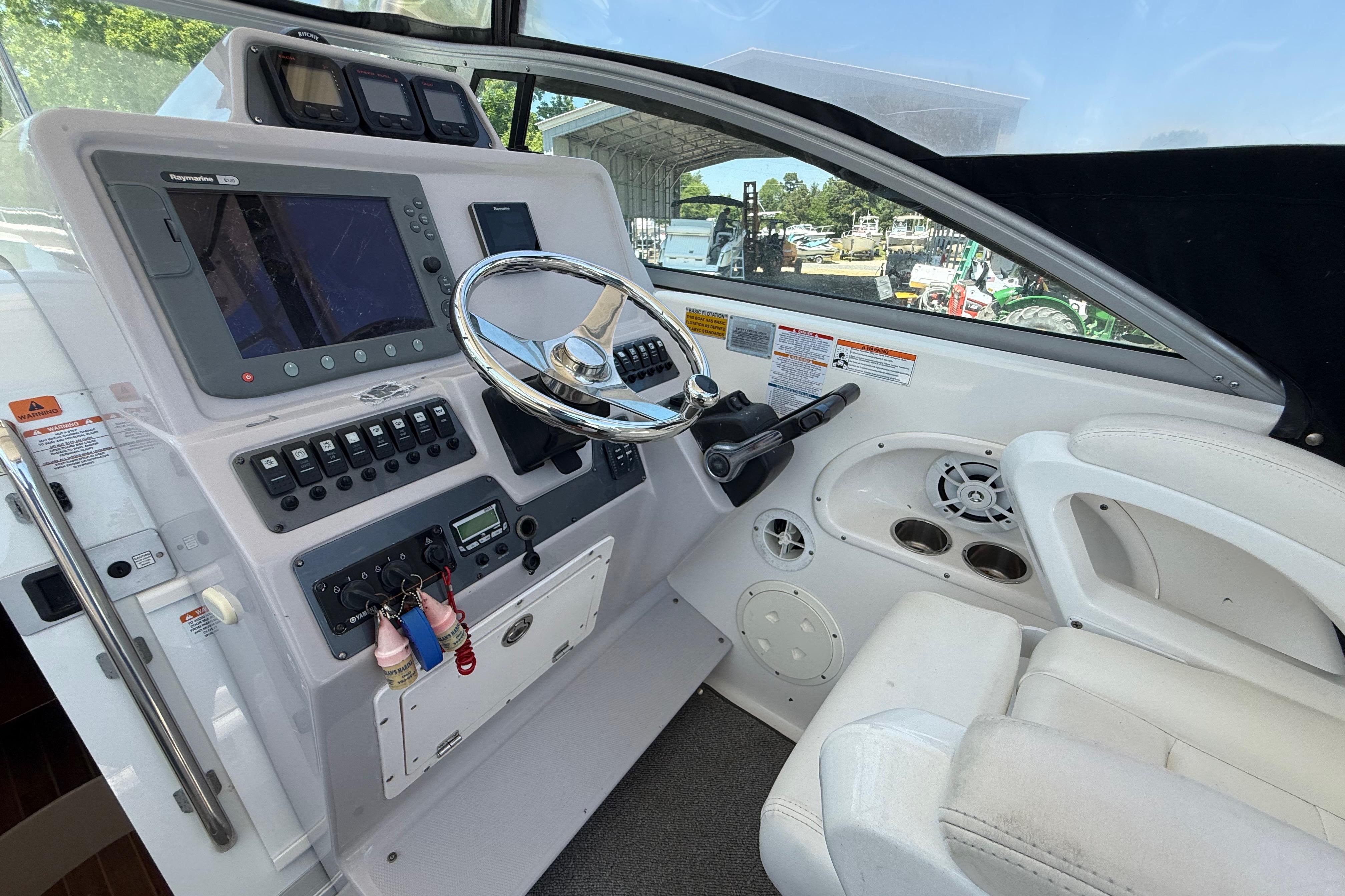 2007 Robalo R305 Walkaround helm with steering wheel, navigation controls, and white seating.