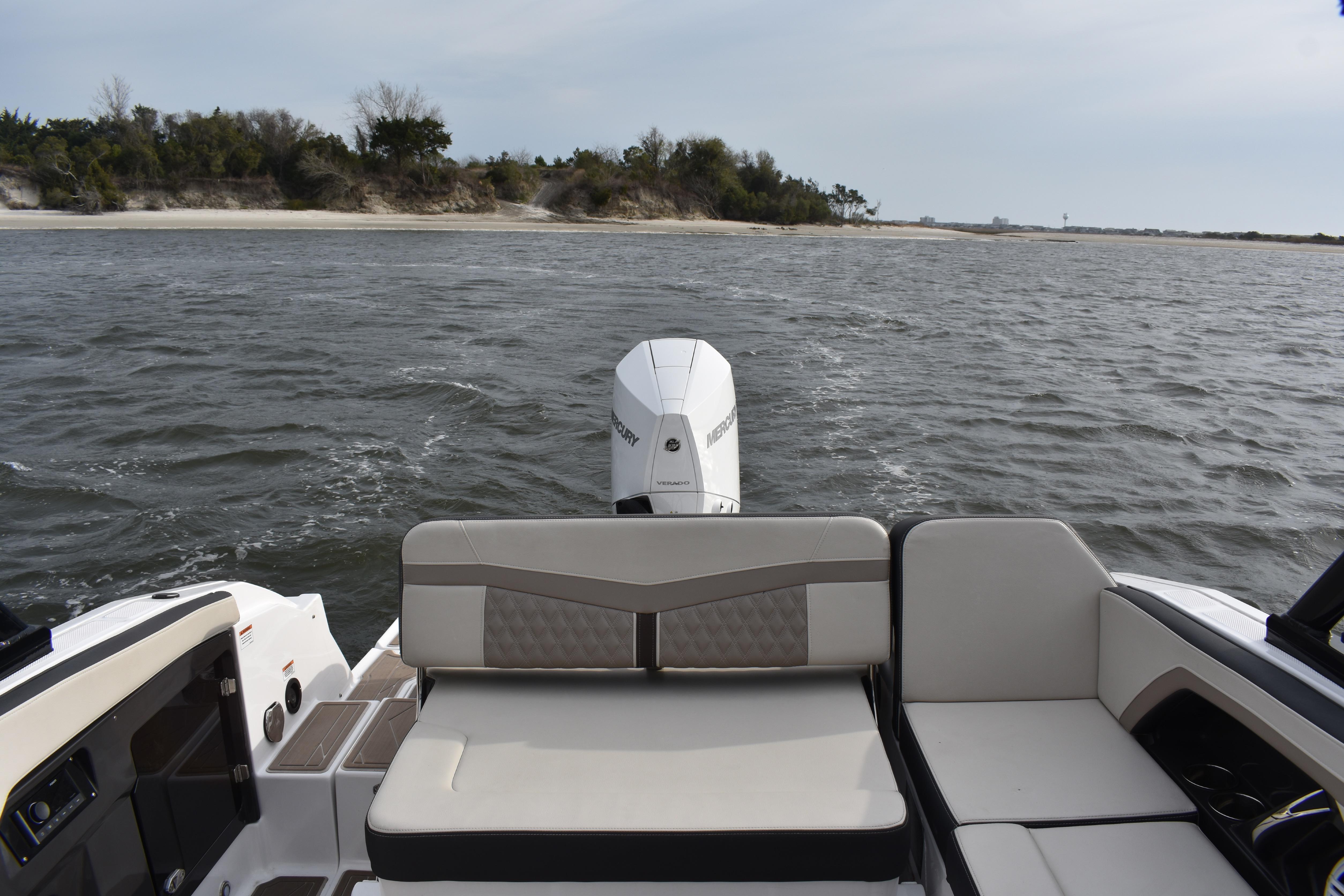 2024 Monterey 255SS Super Sport boat on water, featuring comfortable seating and scenic shoreline view.