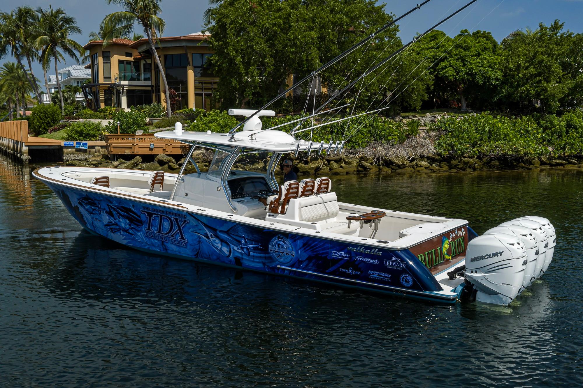 2020 Valhalla Boatworks V-41 with vibrant graphics, docked near lush greenery.
