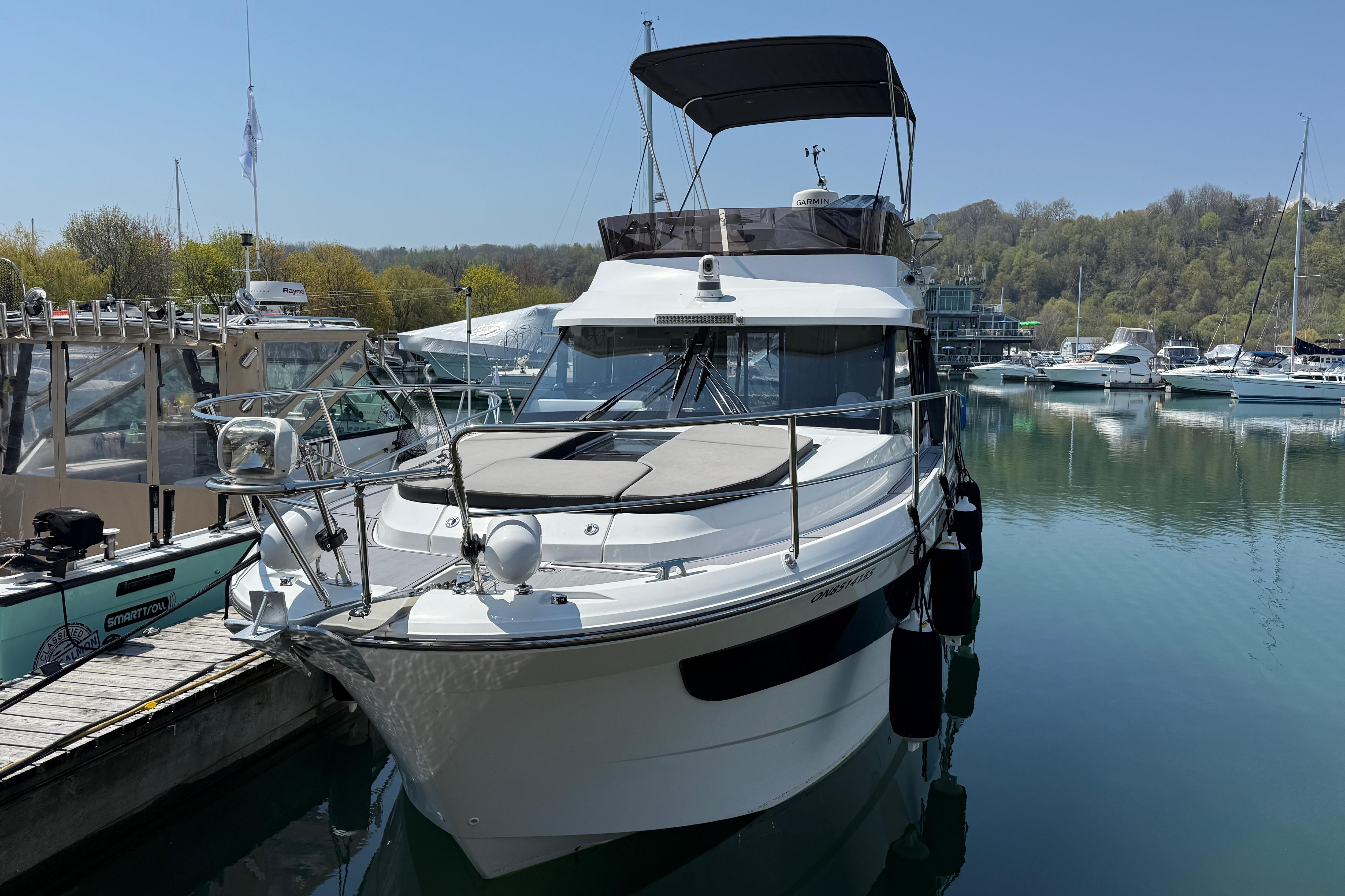 2022 Jeanneau NC 1095 Fly yacht docked in a serene marina setting.