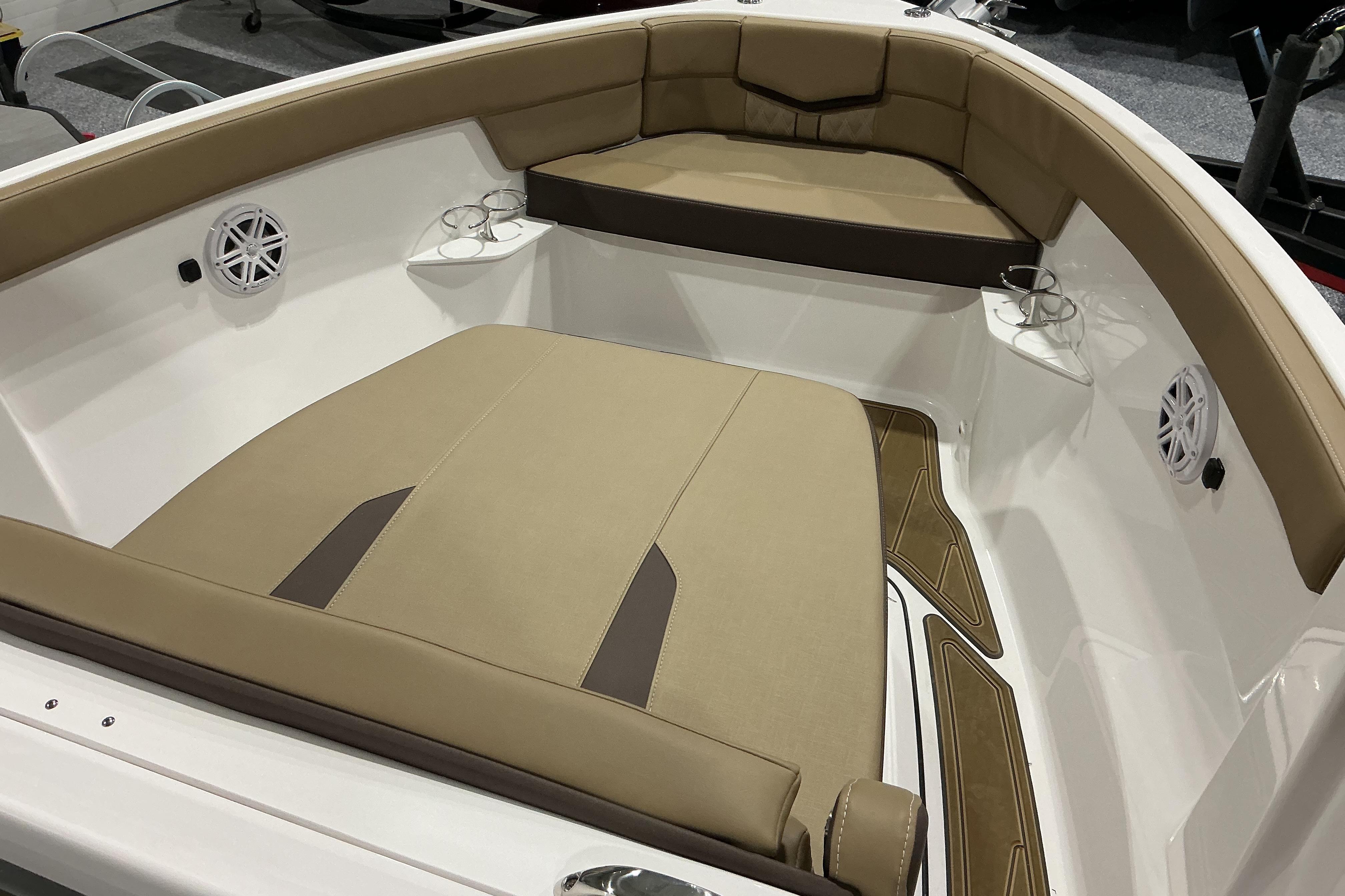 Luxurious seating area of 2026 Monterey Elite 25 OB boat with cup holders and speakers.