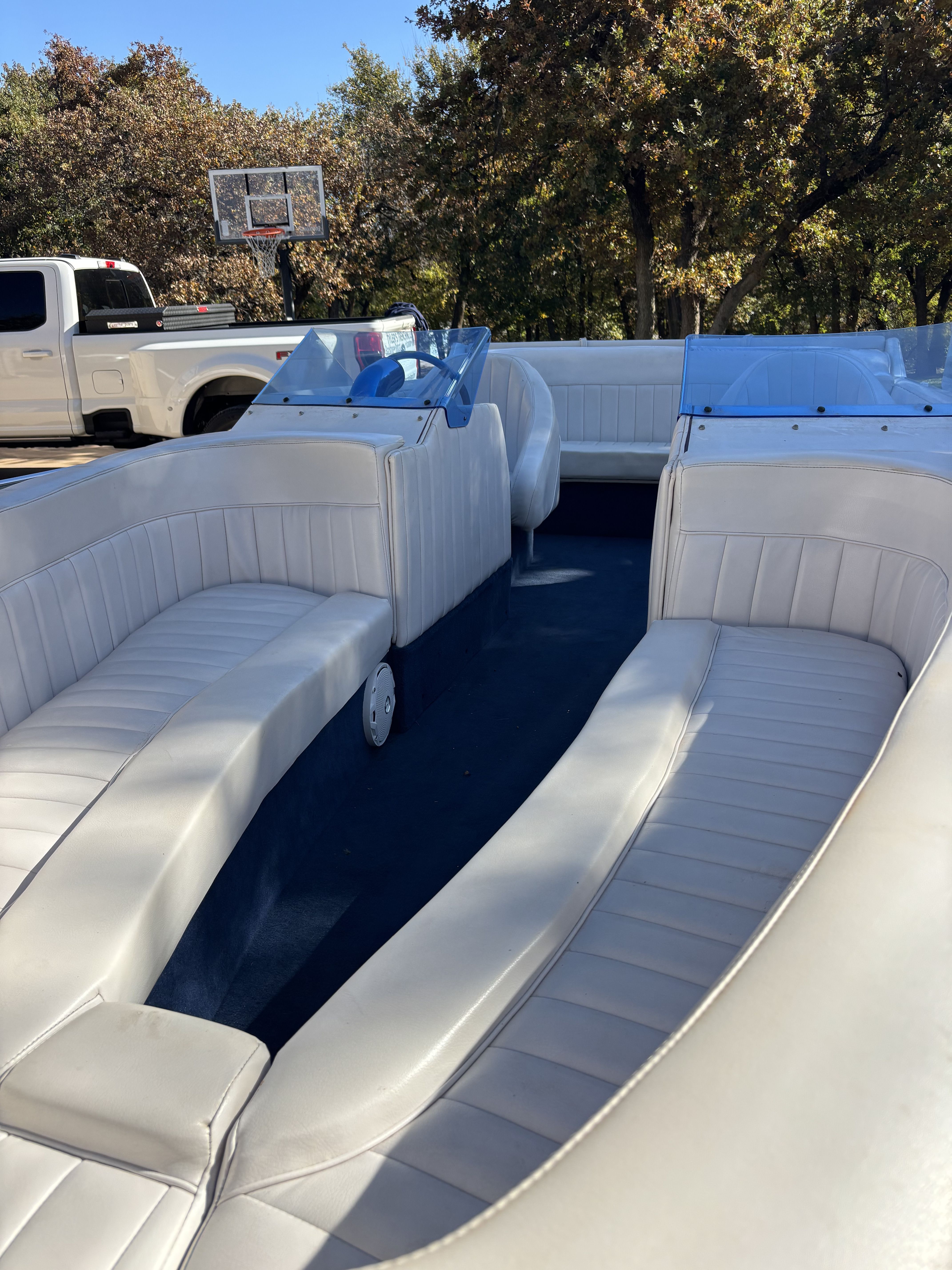 Interior view of a 1984 Tahiti Carribean boat with white leather seating and blue accents.