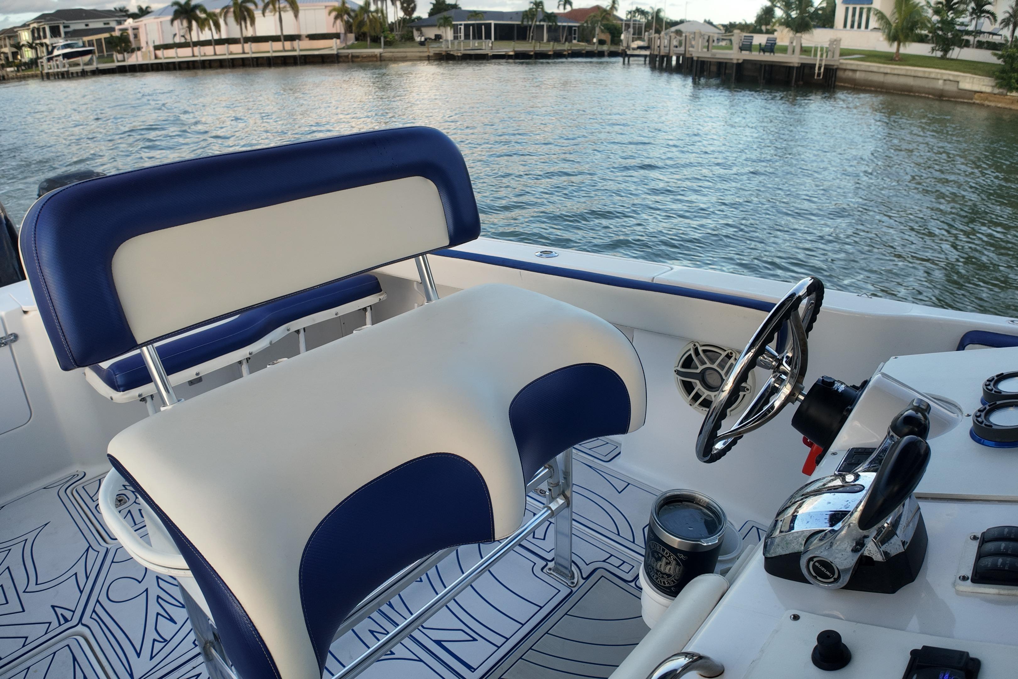 Interior of a 2000 Donzi 35 boat with blue and white seating, steering wheel, and controls.
