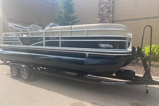2025 Ranger Reata 223FC pontoon boat on trailer, parked outdoors.