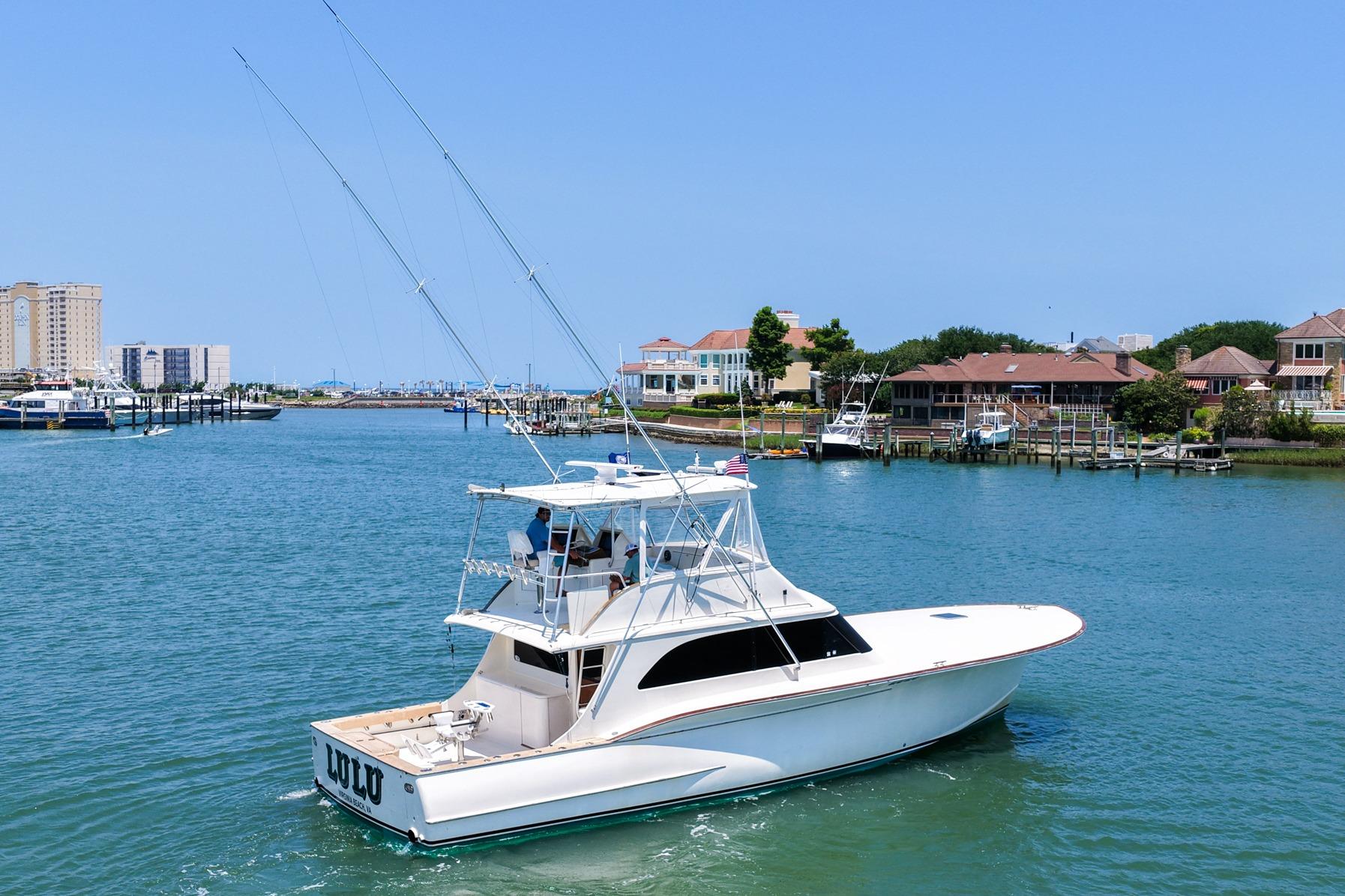 1998 Blackwell Custom Carolina Sportfish yacht cruising in a scenic harbor setting.
