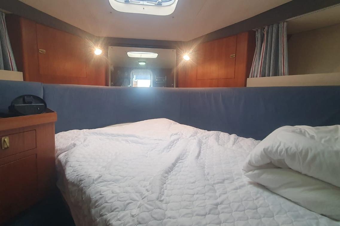 Cozy cabin interior of 1989 Princess 35 yacht with bed and wooden accents.
