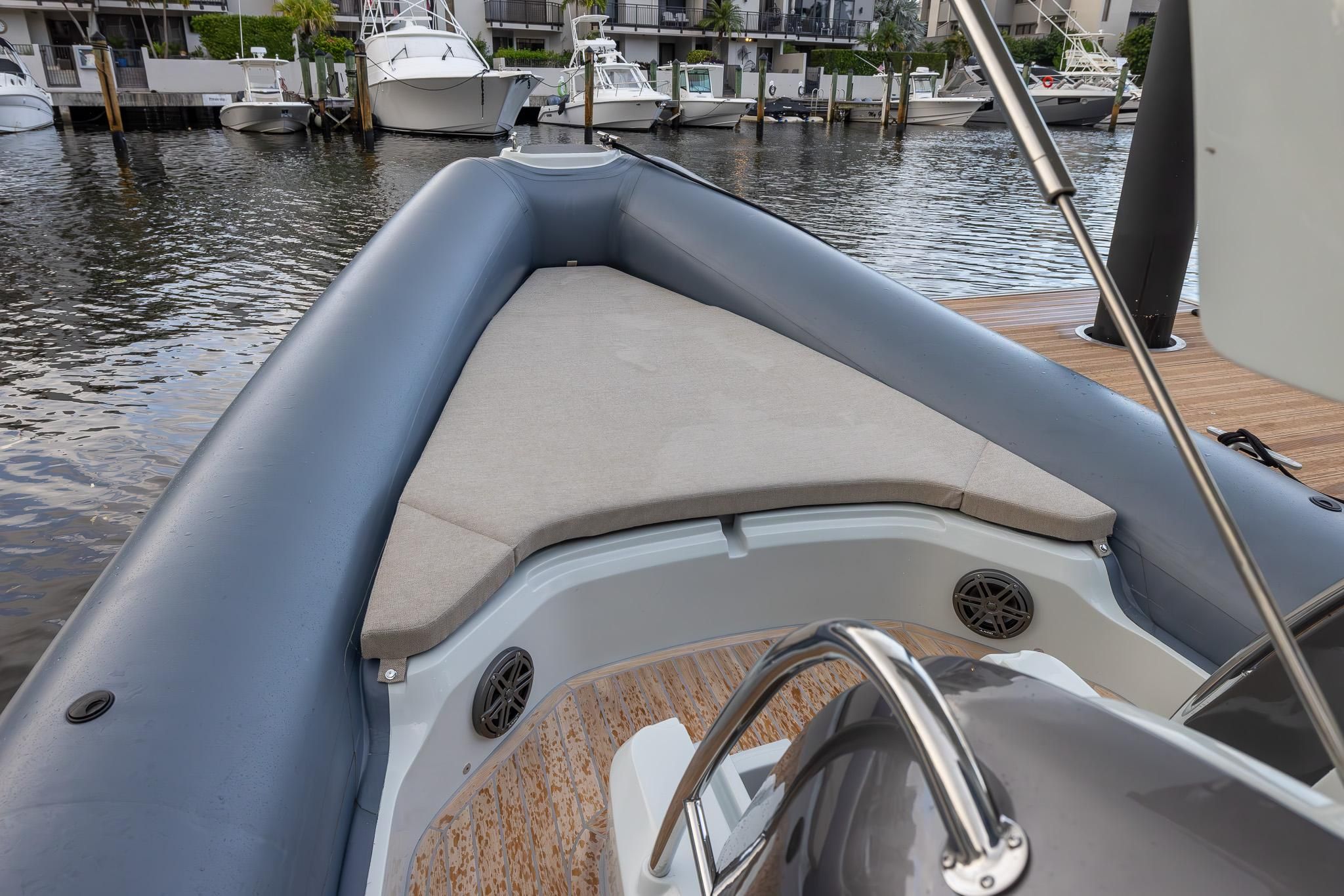 2024 SACS Strider 900 boat with cushioned deck area at the dock.