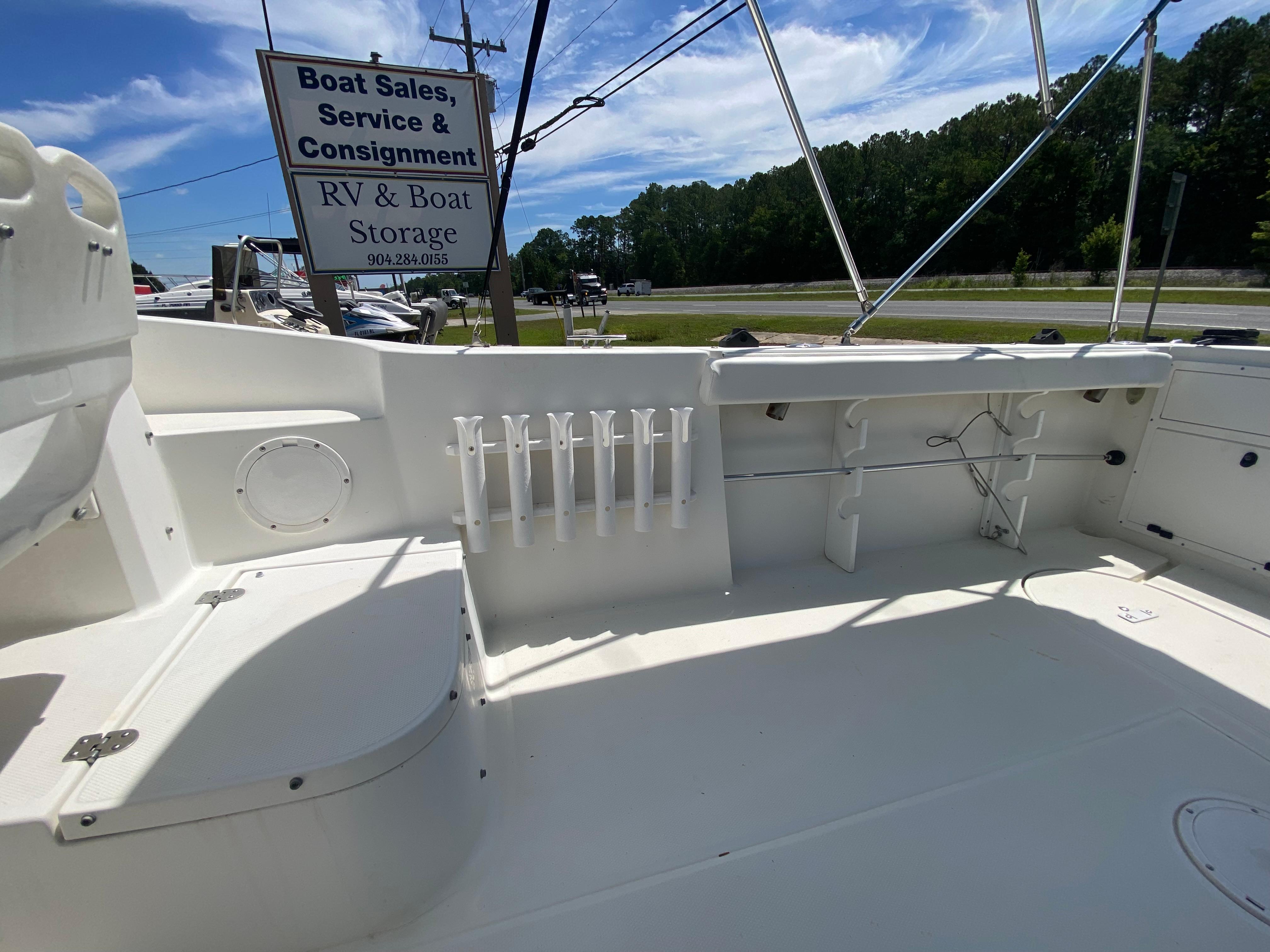 1999 Aquasport 245 Explorer boat deck with rod holders and storage compartments.