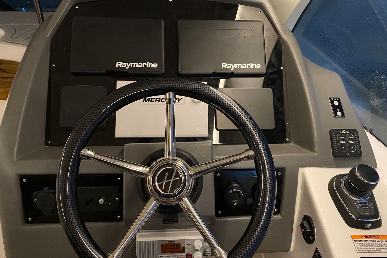 Steering wheel and dashboard of 2026 Hanover 375 boat with Raymarine electronics.