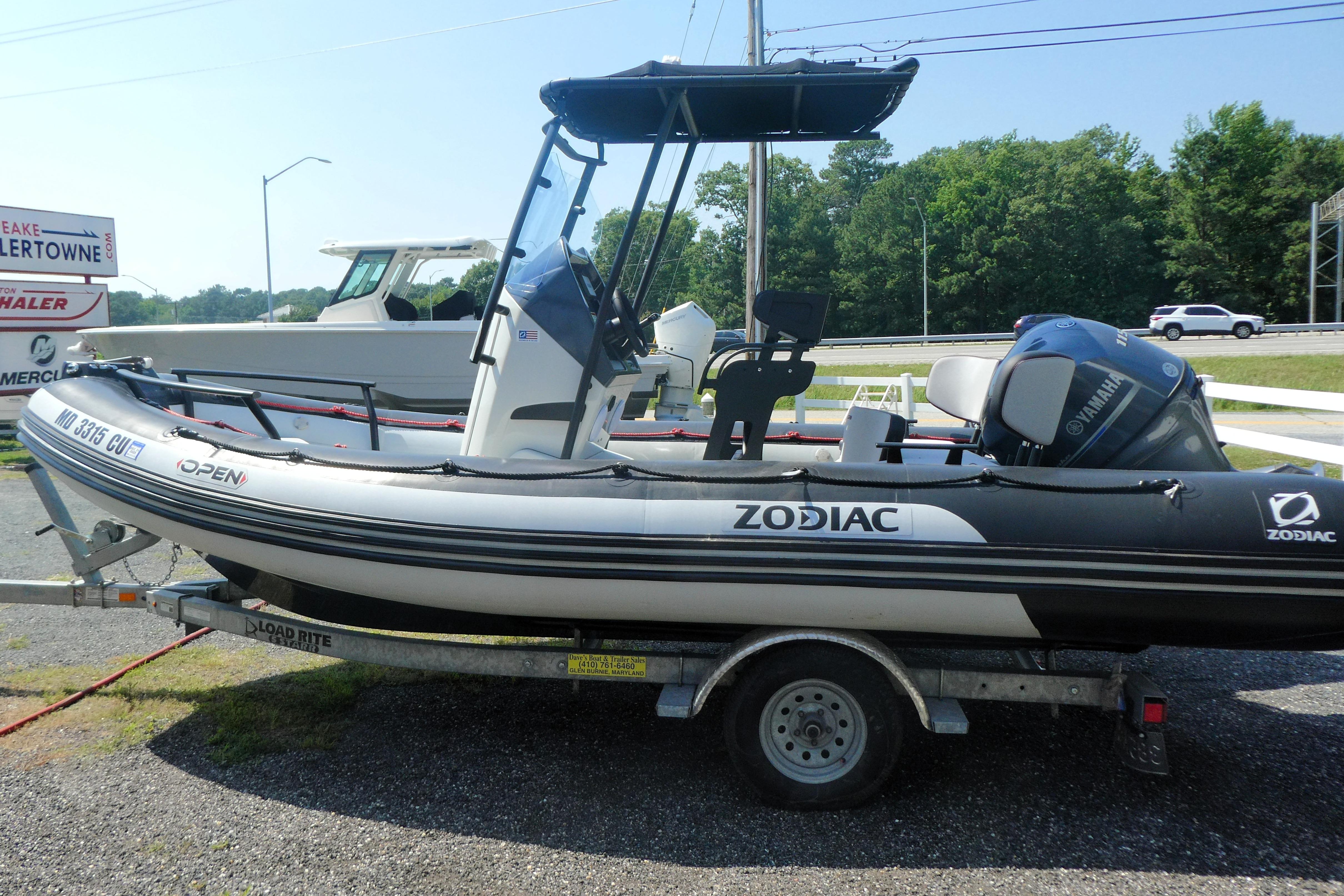 2022 Zodiac Pro 5.5 inflatable boat on trailer, parked outdoors near dealership.