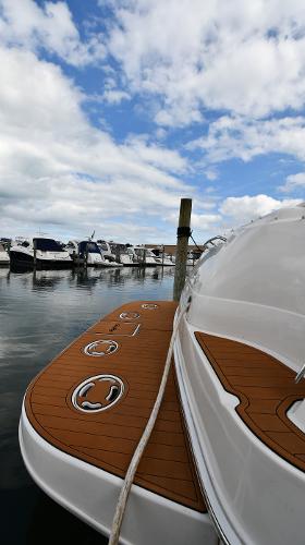 2003 Sea Ray 460 Sundancer yacht docked at marina under cloudy sky.
