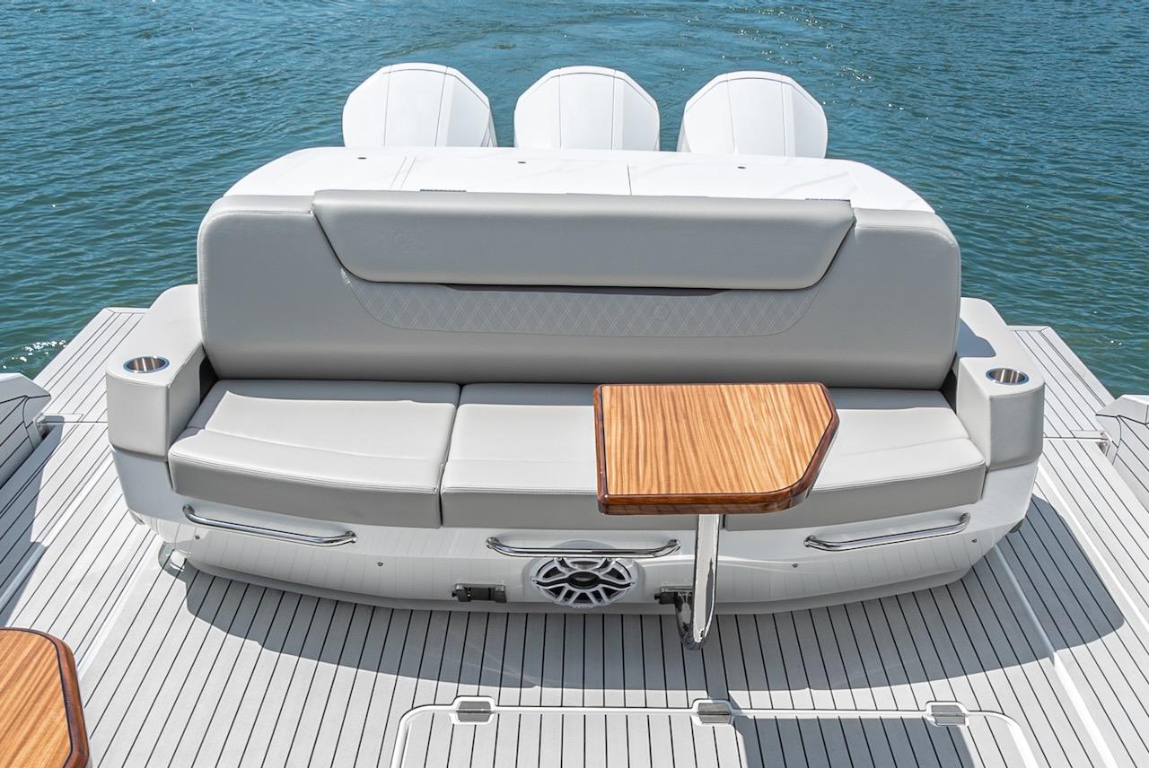 2024 Cruisers Yachts 50 GLS rear seating area with wooden table on deck.