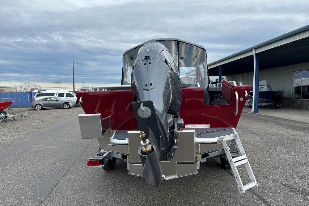 2026 Weldcraft 210 Revolution boat with outboard motor, parked outdoors.