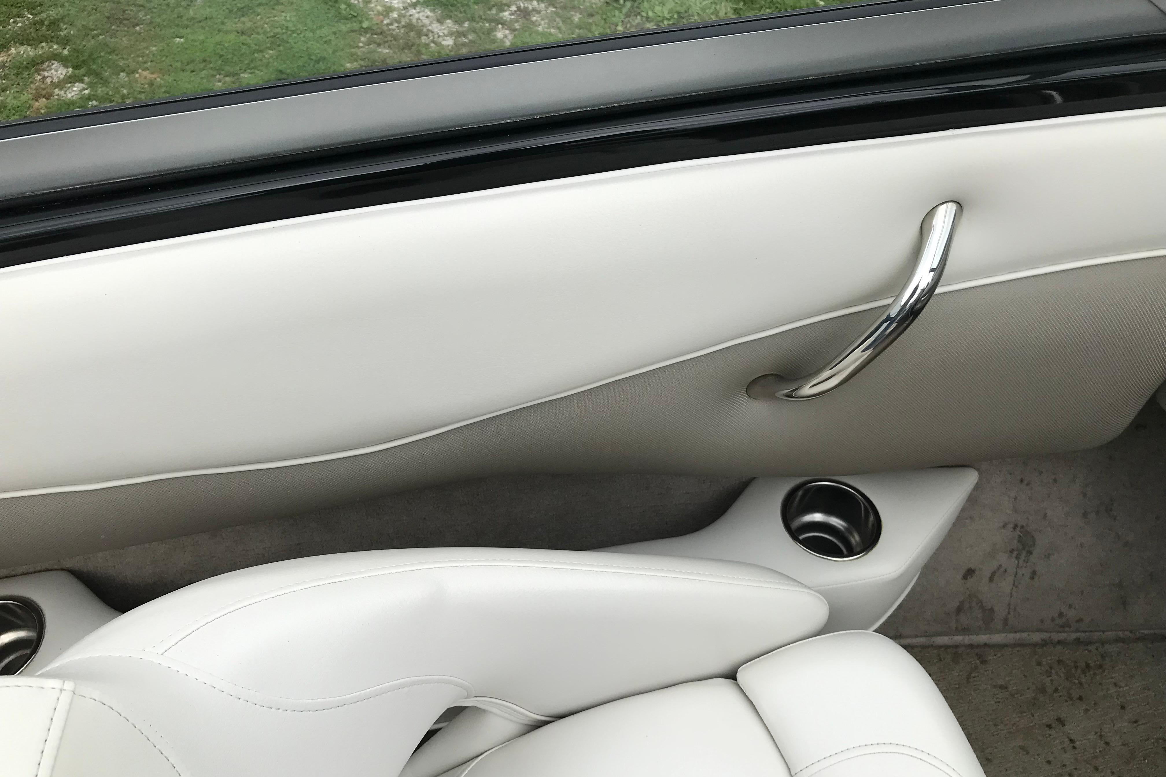 Interior of a 2015 Crownline 18 SS boat, featuring white upholstery and chrome accents.