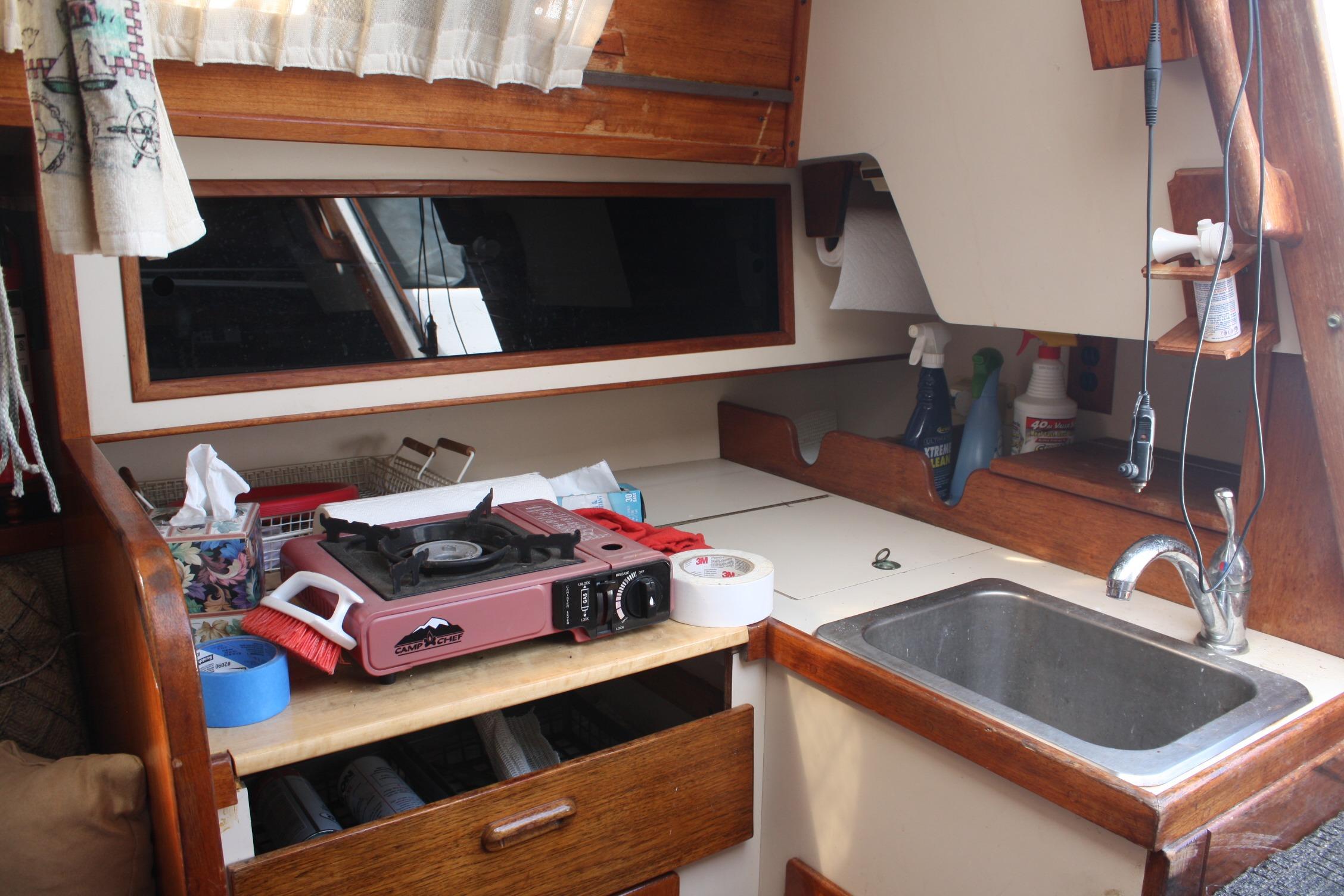 1981 S2 9.2A sailboat galley with stove, sink, and storage.