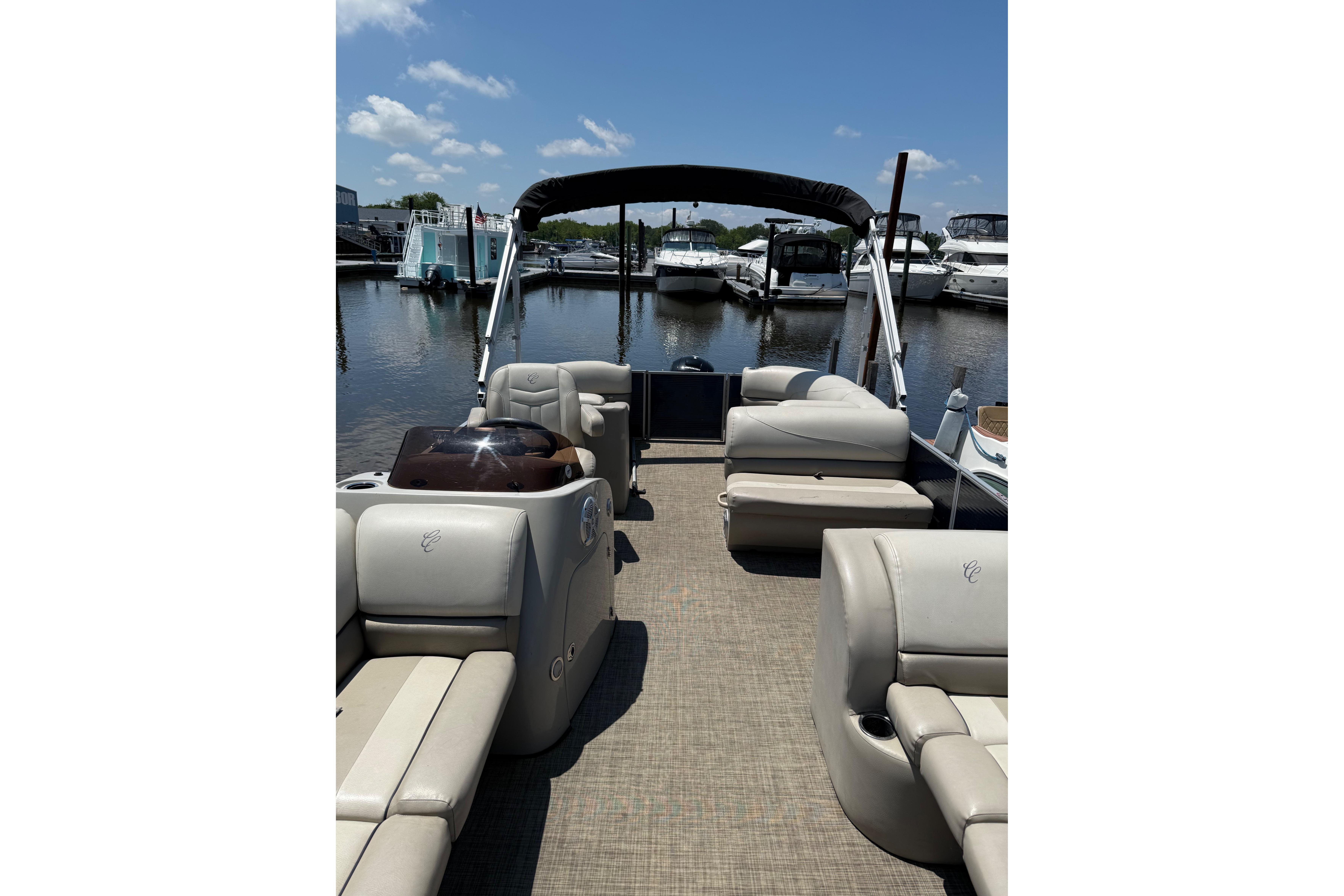 2023 Cypress Cay Seabreeze 232 pontoon boat interior at marina, sunny day.