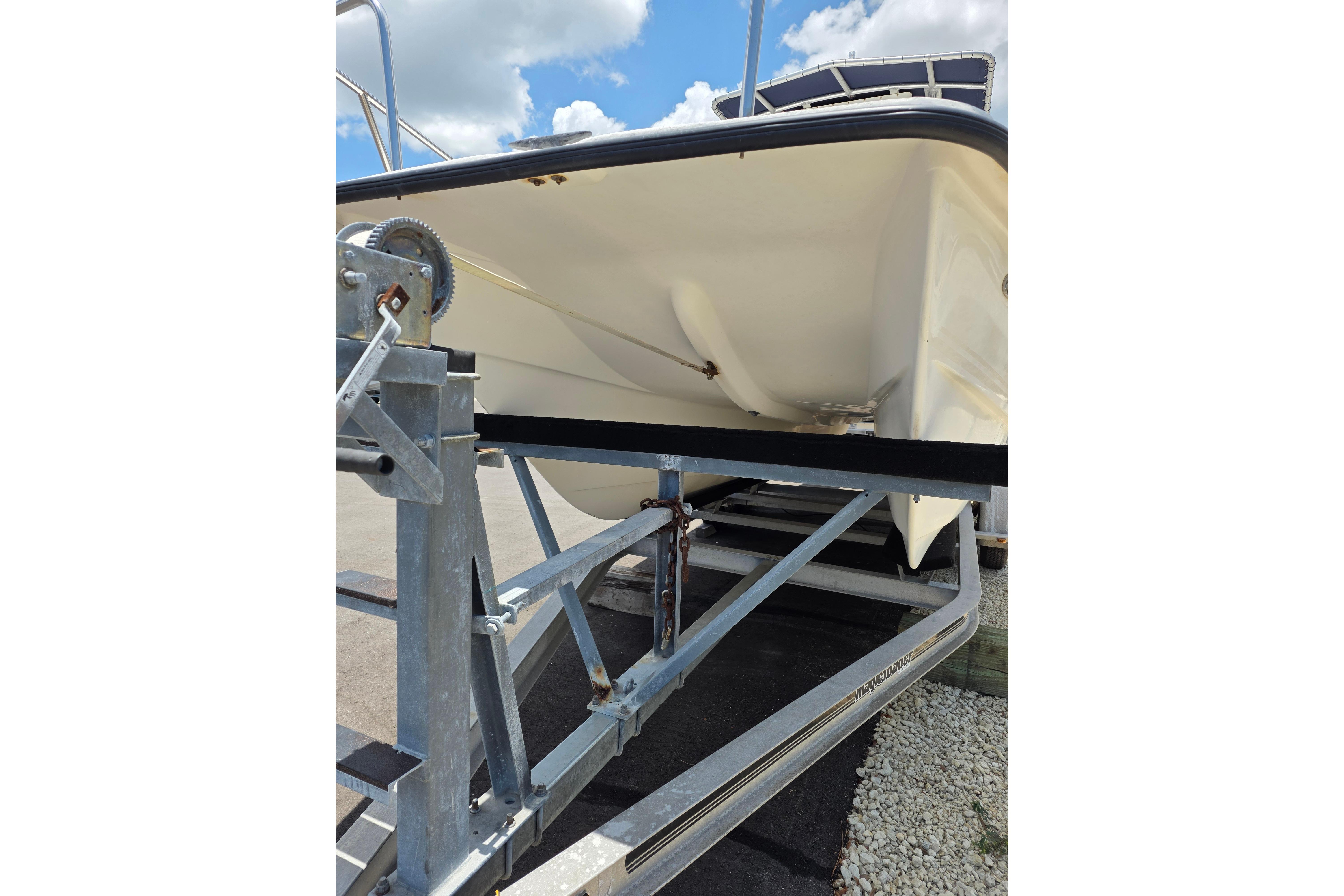 1999 Twin Vee Awesome 22 boat on trailer under a bright blue sky.