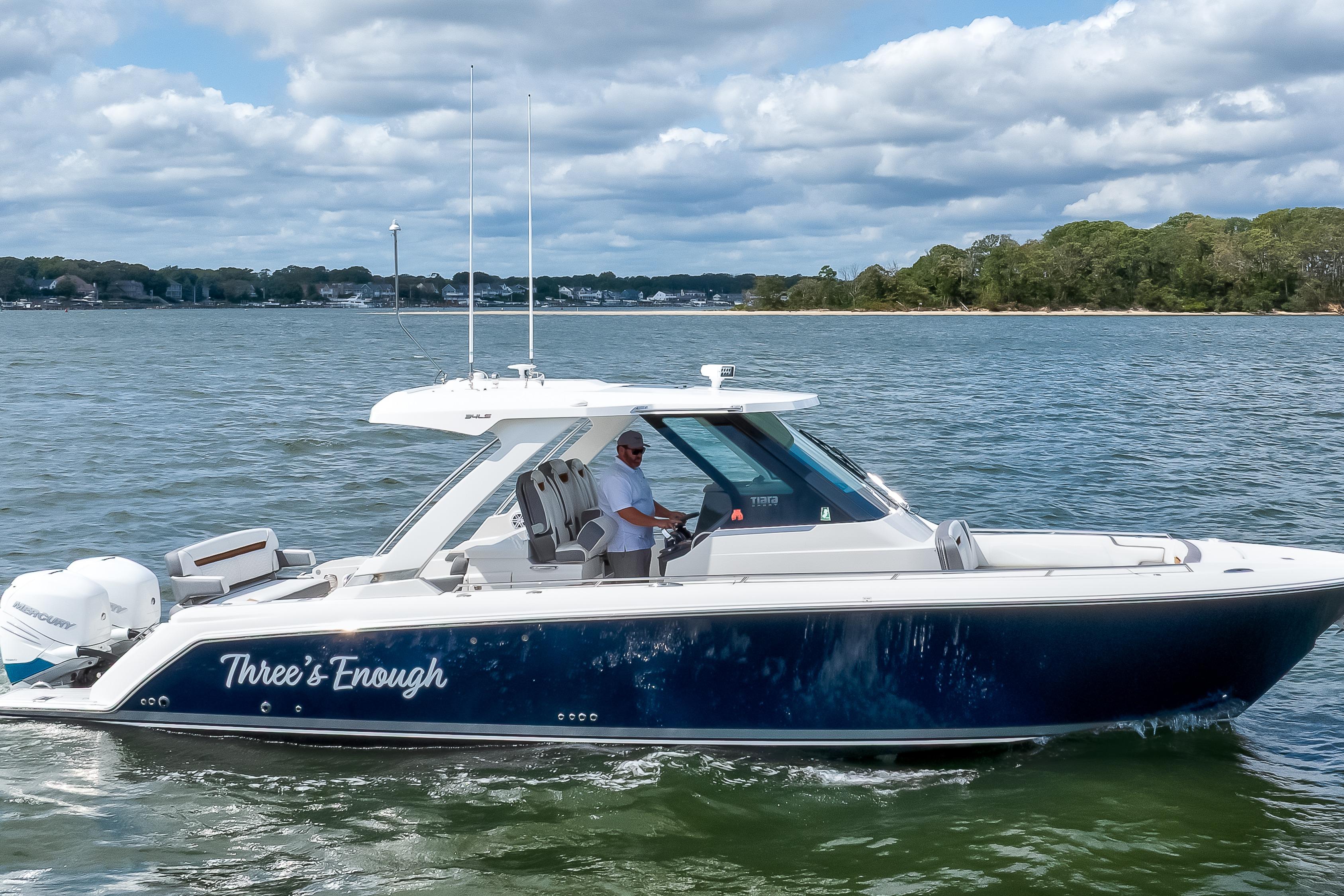 2020 Tiara Sport 34 LS boat cruising on a scenic lake with a clear sky.