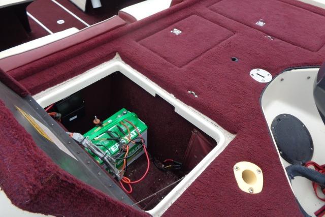 1996 Quantum 180 XD boat interior with open battery compartment, red carpet, and wiring visible.
