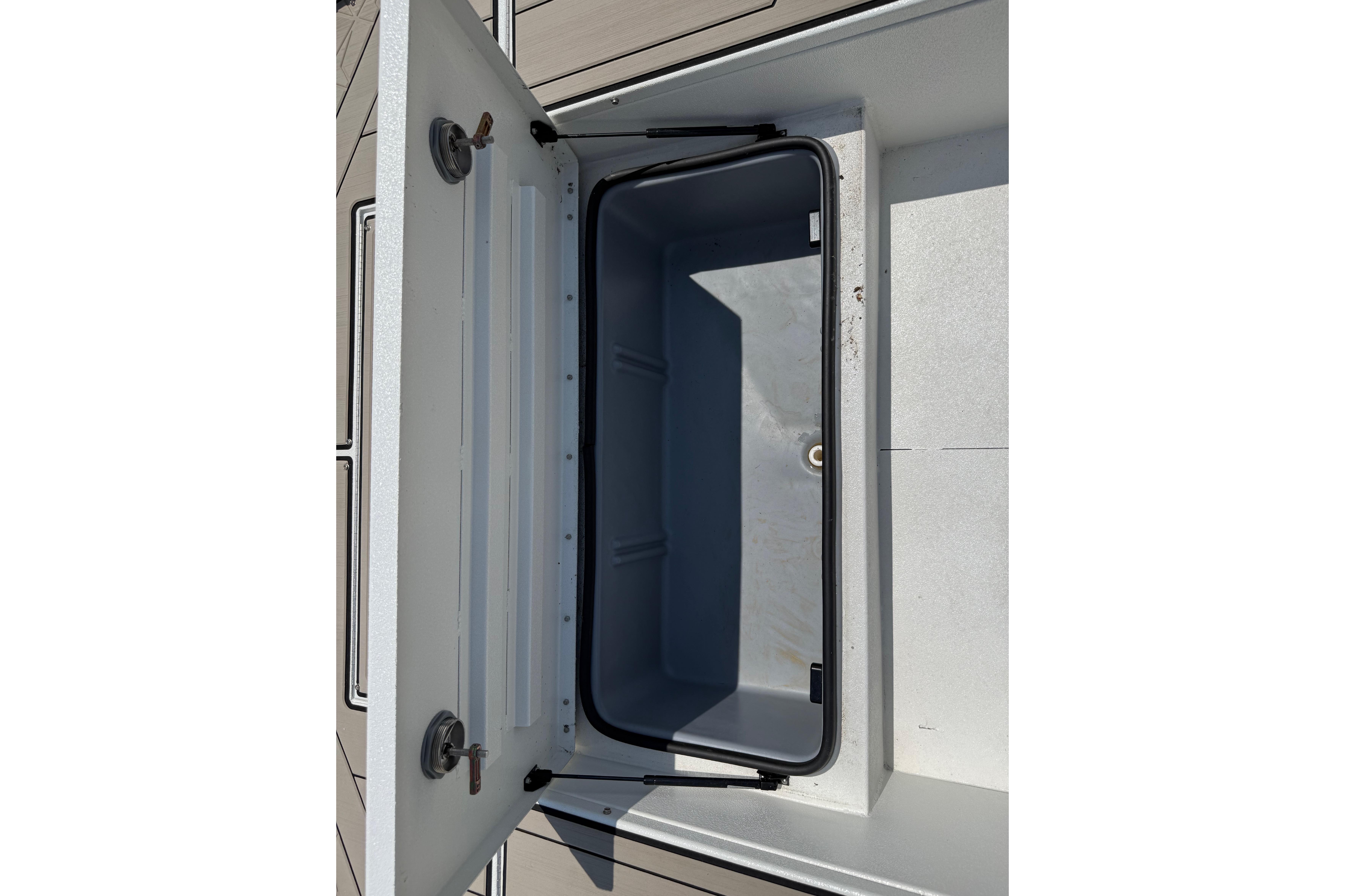Open storage compartment of 2025 Avid 22 Recon boat, showcasing interior space.
