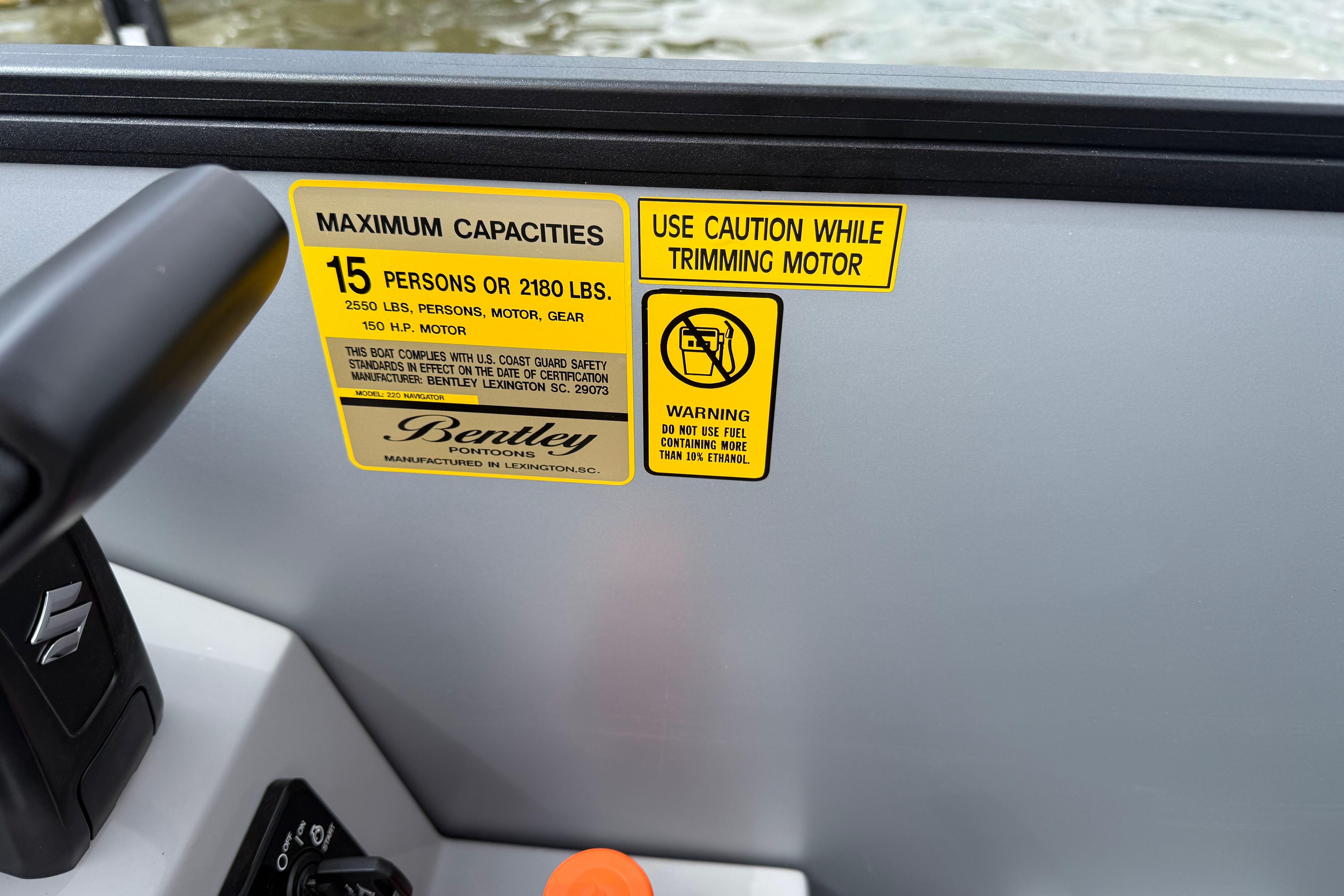 Safety labels on 2026 Bentley Pontoons Legacy 220 Navigator, detailing capacity and fuel warnings.