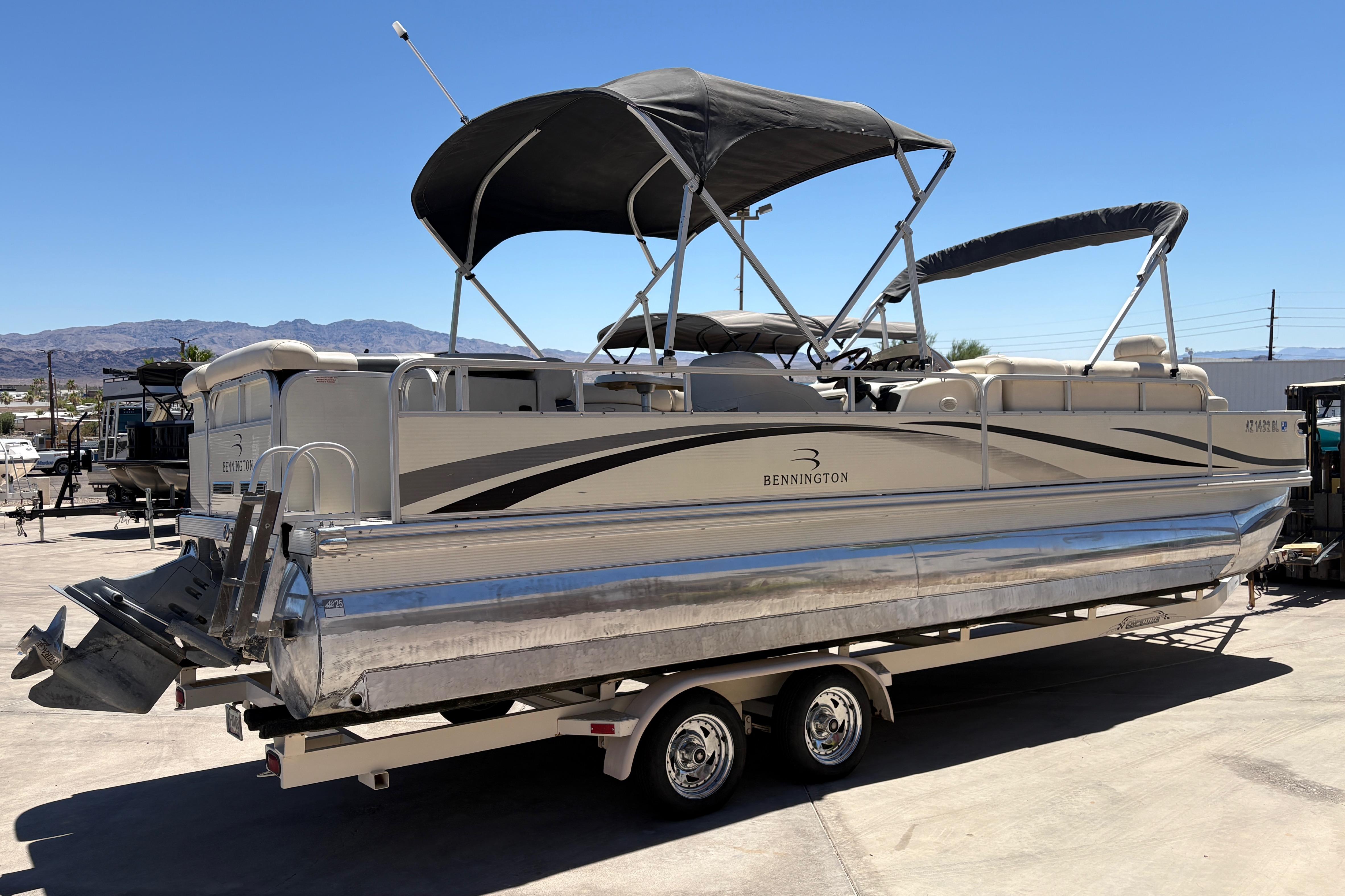 2005 Bennington 2575RFS I/O pontoon boat on trailer, with canopy, in outdoor setting.