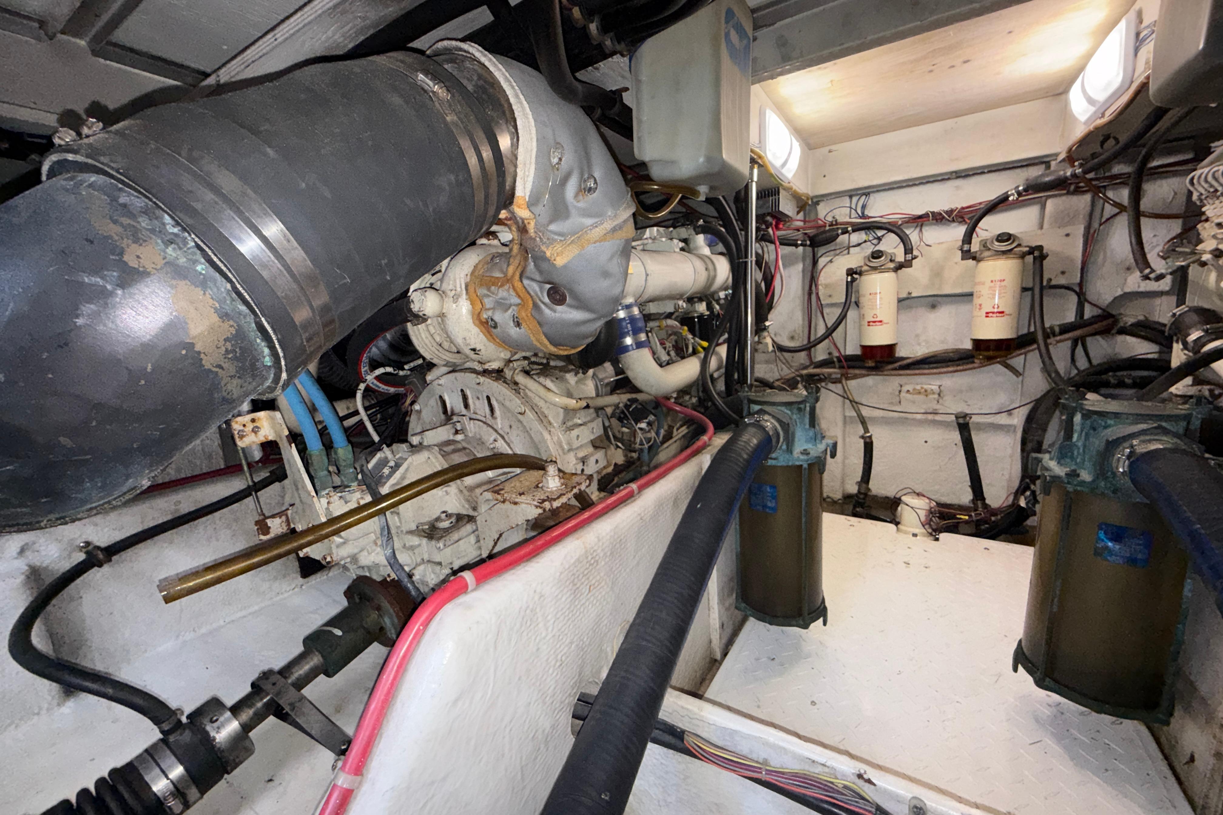 Engine room of 1997 Bayliner 3988 Command Bridge Motoryacht, showcasing mechanical components and wiring.