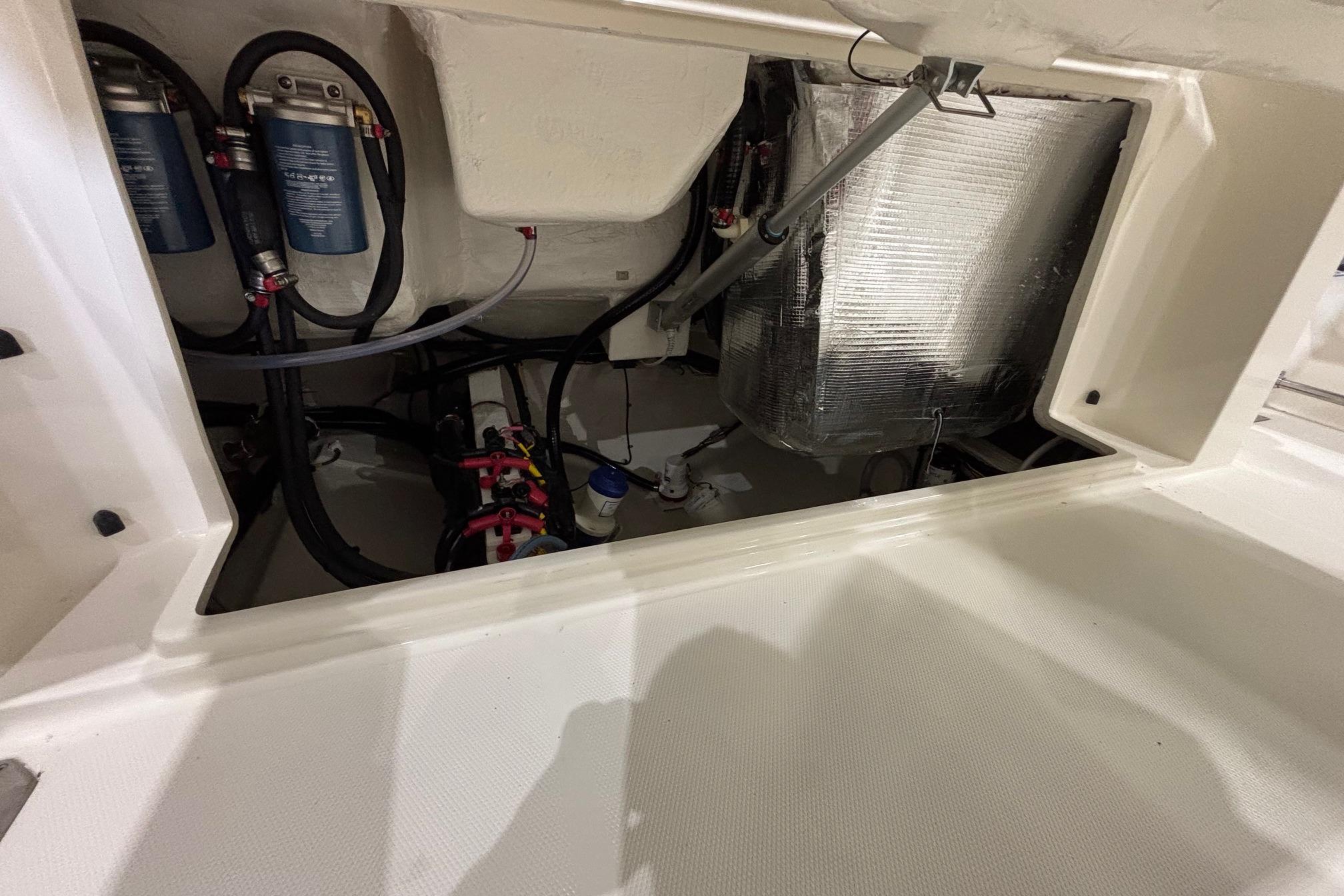 2026 Cobia 285 Open Center Console boat engine compartment with filters and wiring.