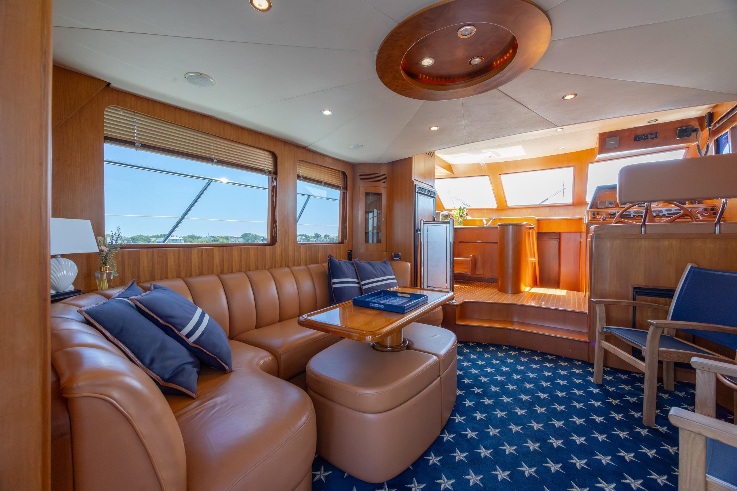 Luxurious interior of 2005 Ocean Alexander 52 Sedan yacht with leather seating and star-patterned carpet.
