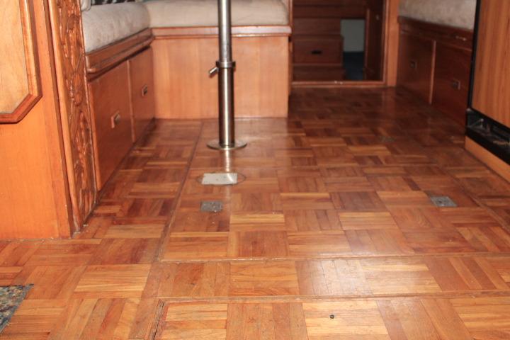 1976 CHB Double Cabin Trawler interior with wooden parquet flooring and built-in seating.