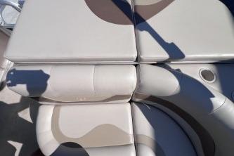 2012 Avalon Tahoe boat seating with beige upholstery and cup holder.