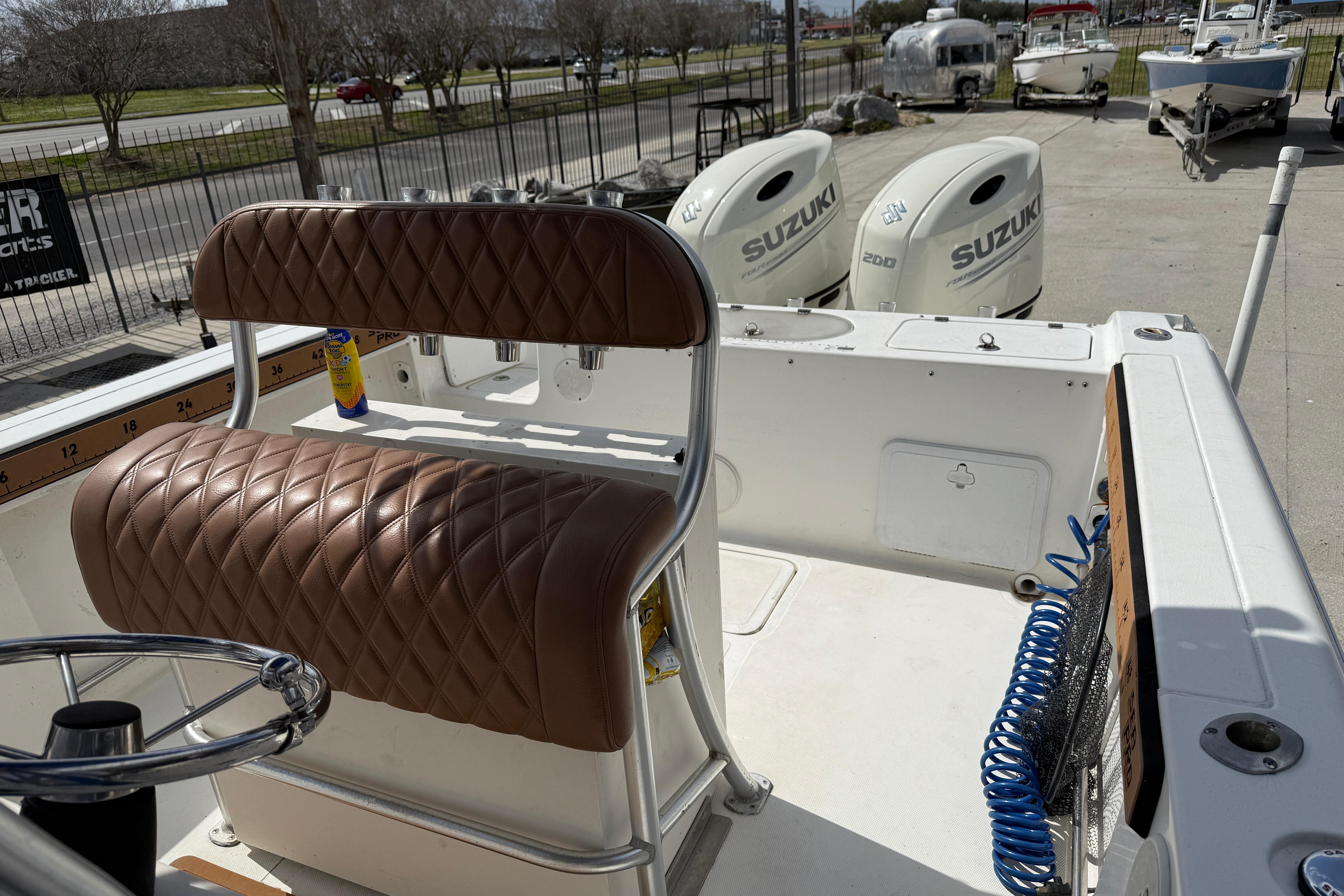 2007 Sea Pro 270 Center Console boat with Suzuki engines and brown quilted seating.