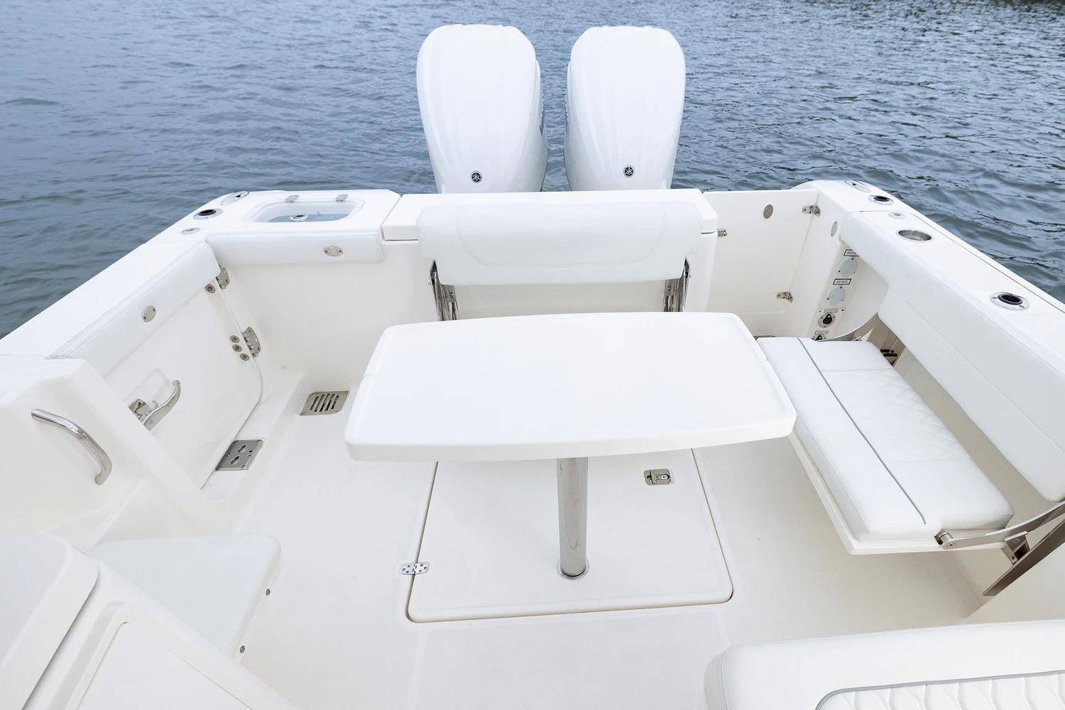 Manufacturer Provided Image: 2026 Pursuit DC 286 Dual Console boat interior with seating and table on water.