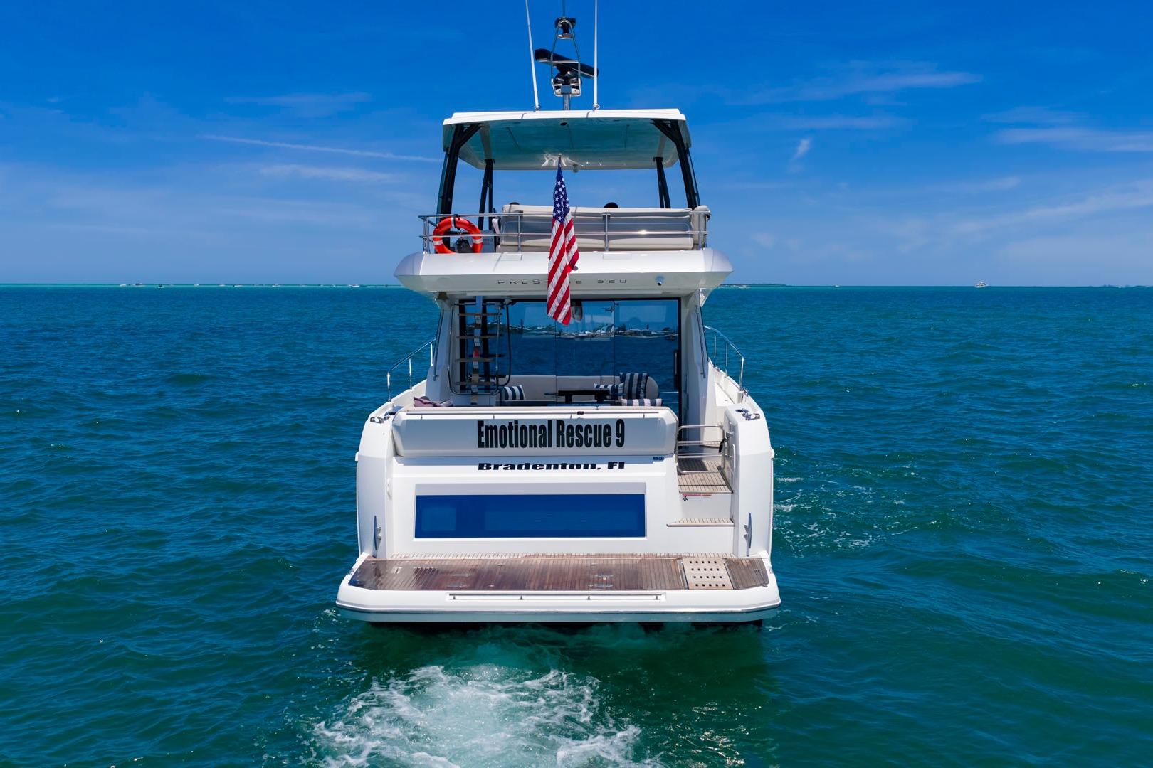 Luxury 2022 Prestige 520 yacht cruising in clear blue ocean waters.