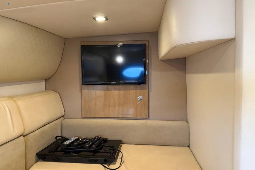 Interior of a 2016 Formula 37 Performance Cruiser with a TV and beige sofa.