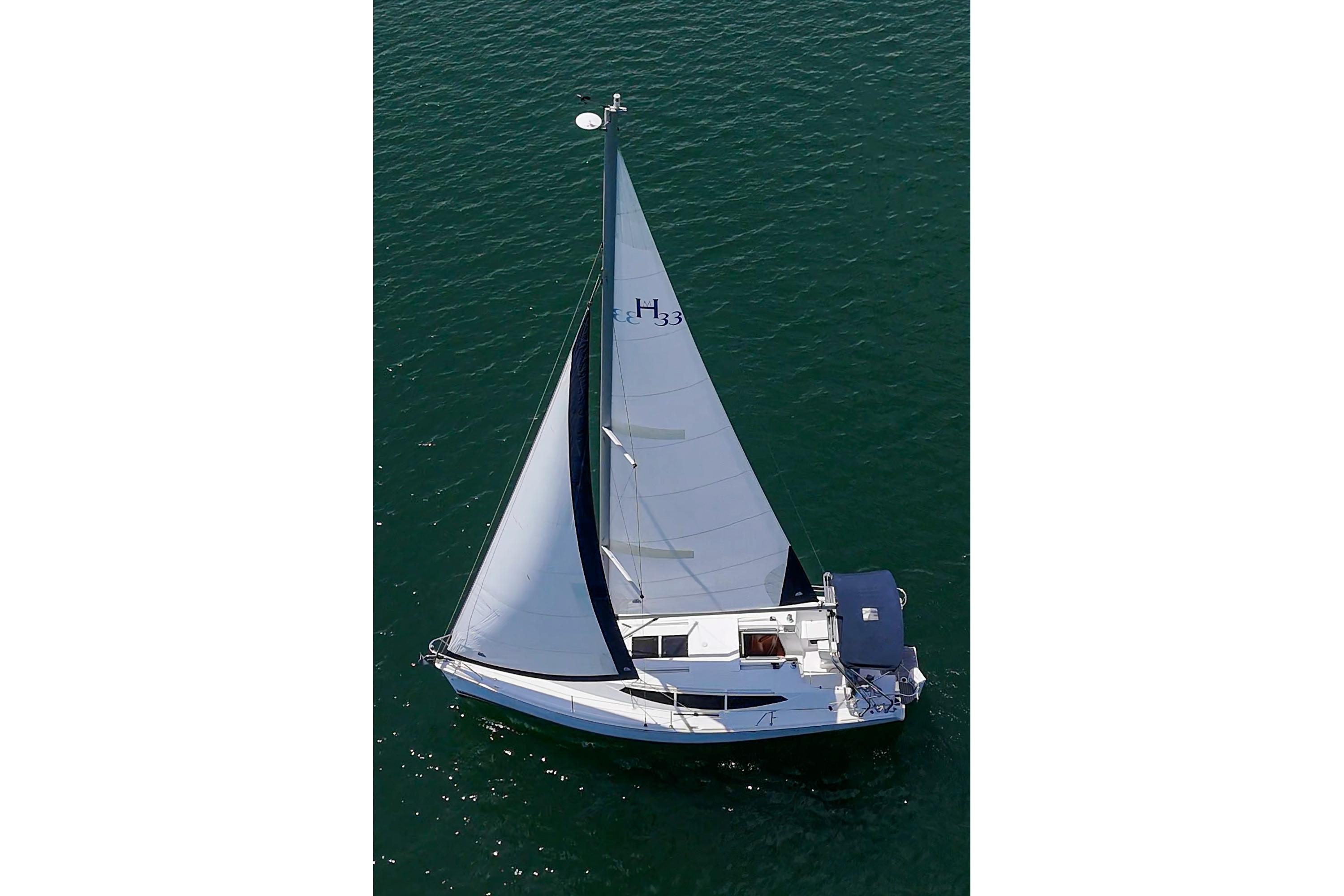 Aerial view of a 2015 Hunter 33 sailboat gliding on calm waters.
