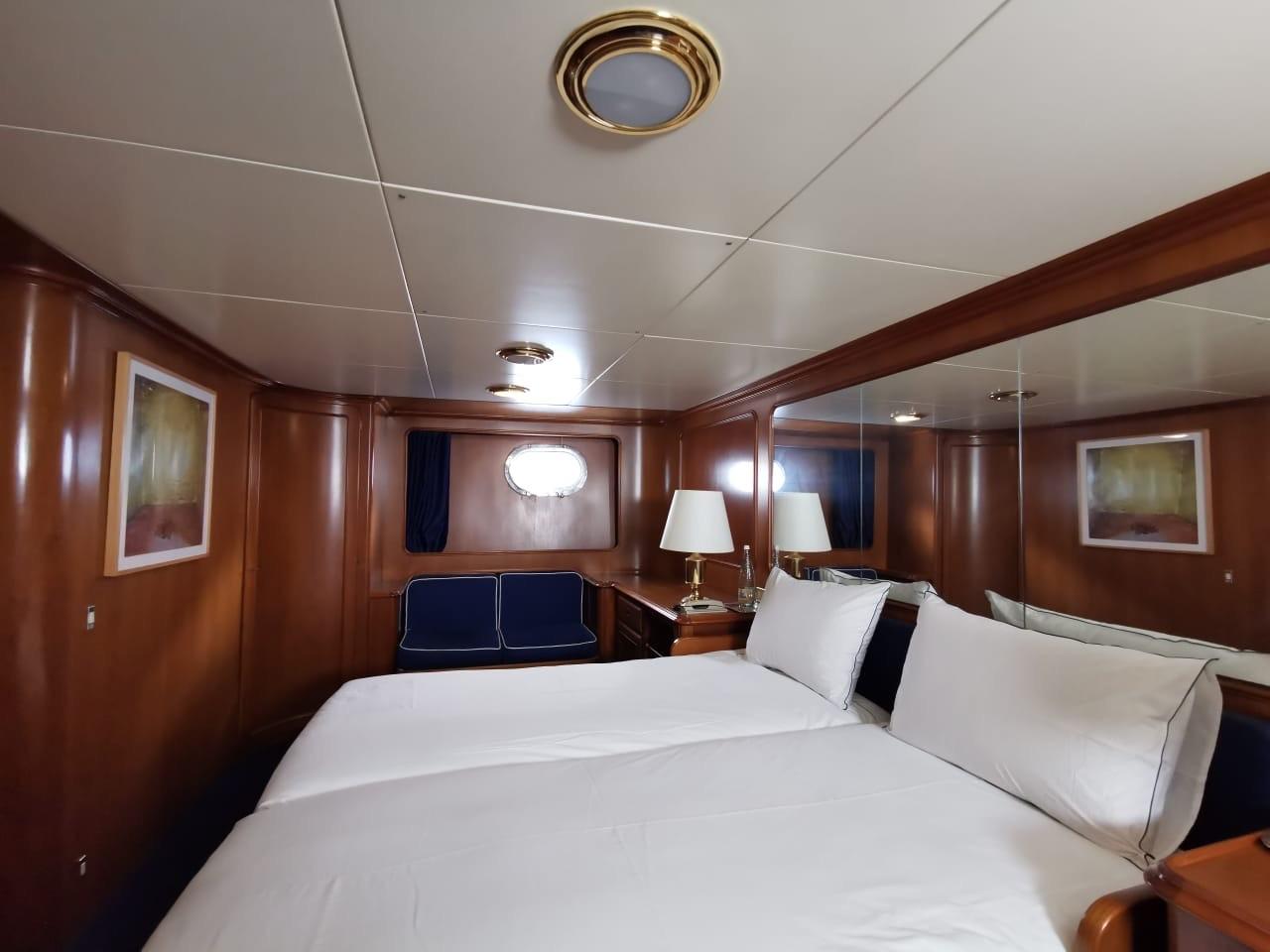 Luxurious cabin interior of 1988 Codecasa Displacement yacht with elegant wood paneling and twin beds.