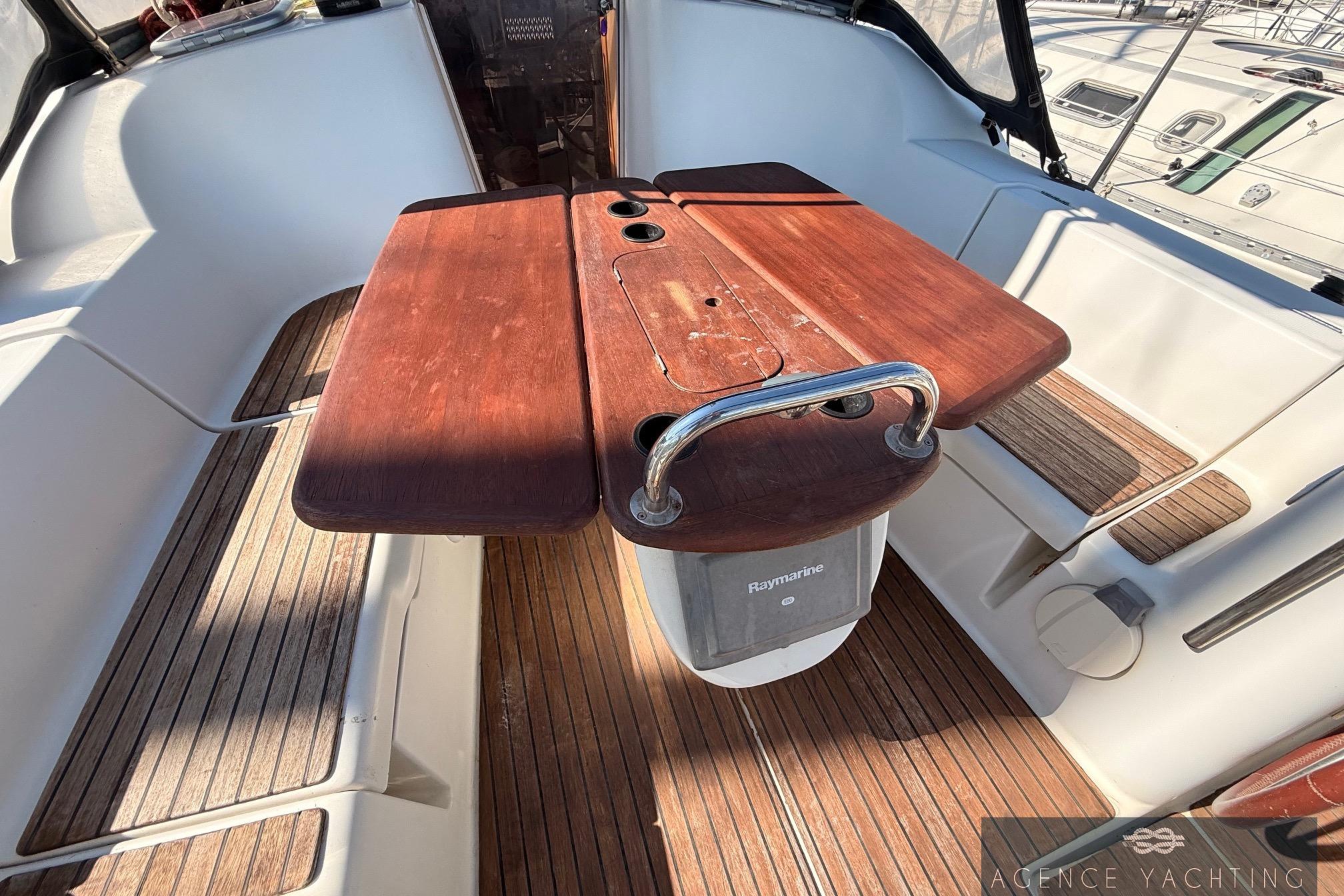 Cockpit of 2009 Jeanneau Sun Odyssey 39i Performance with wooden table and seating.